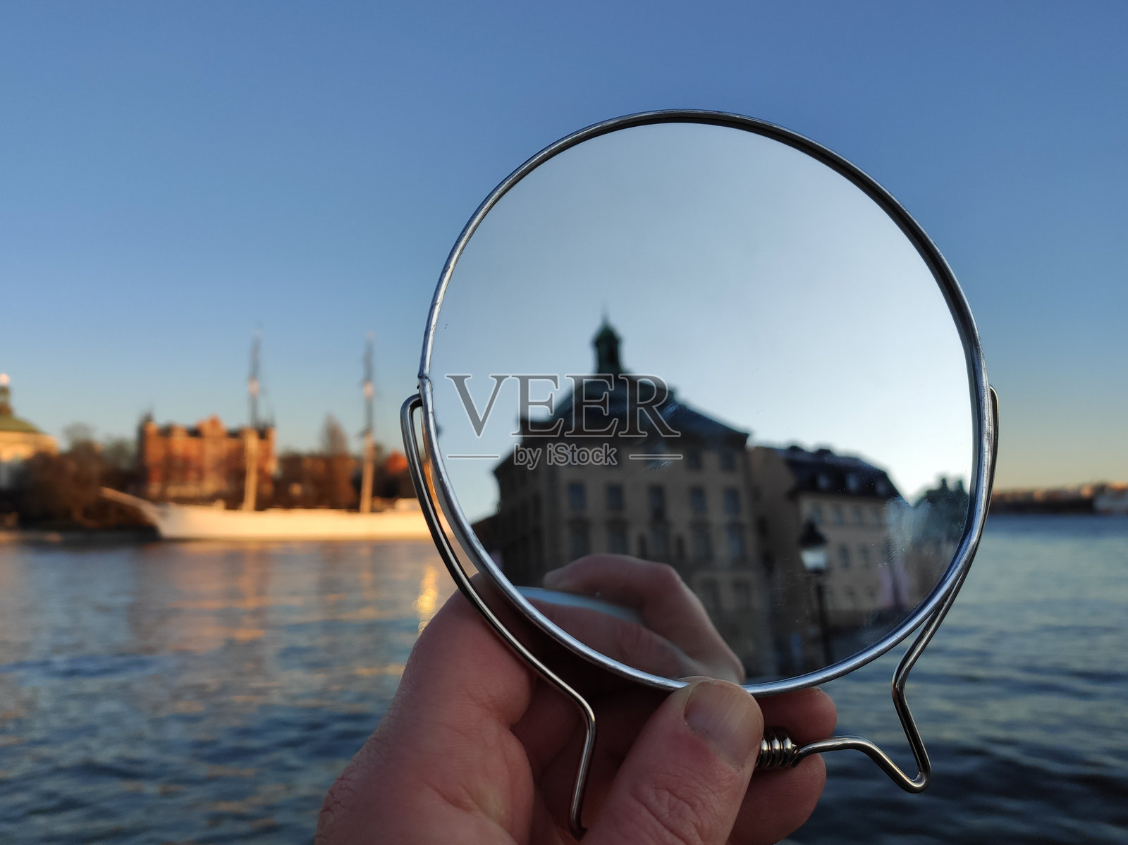 城市中一只手握着镜子照片摄影图片