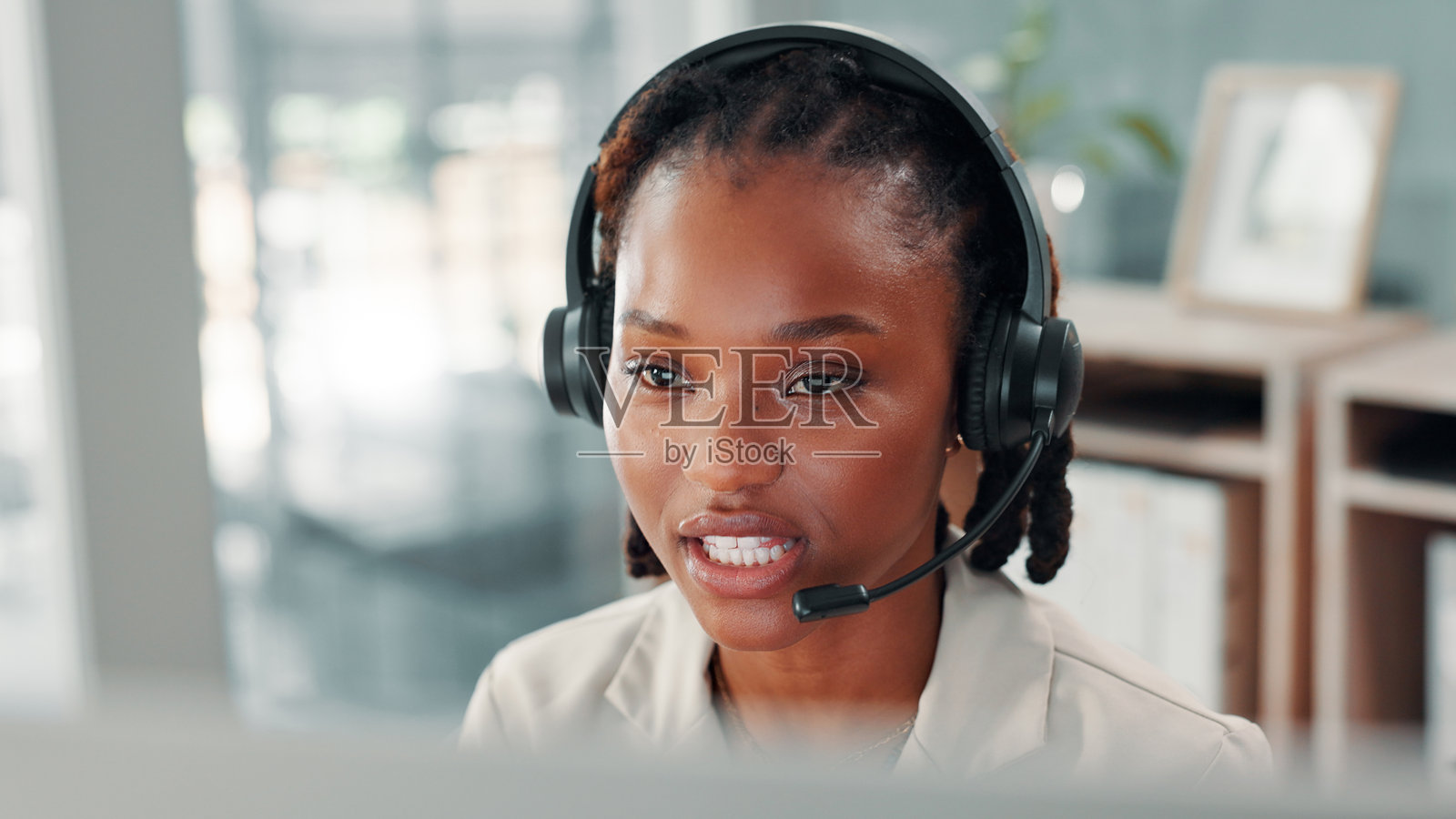 黑人女性，佩戴耳机的呼叫中心工作人员，在办公室中进行外拨电话或电话营销。商业、沟通以及与非洲销售顾问在电脑上进行电信联系。照片摄影图片