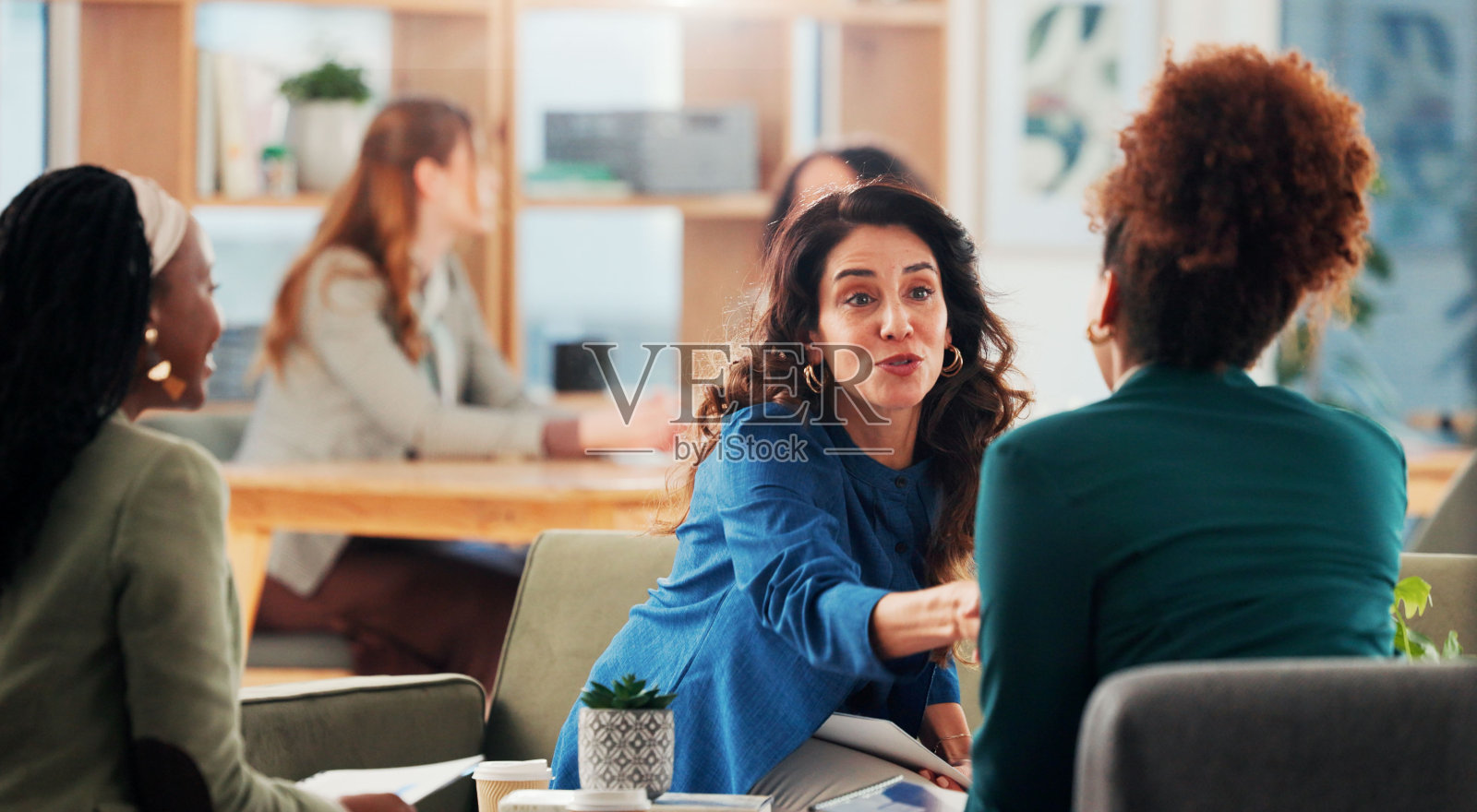 商务女性在办公室进行会议或握手，手中持有面试、简历审核或求职申请的文件。女性同事在工作场所握手达成协议、交易或合同。照片摄影图片