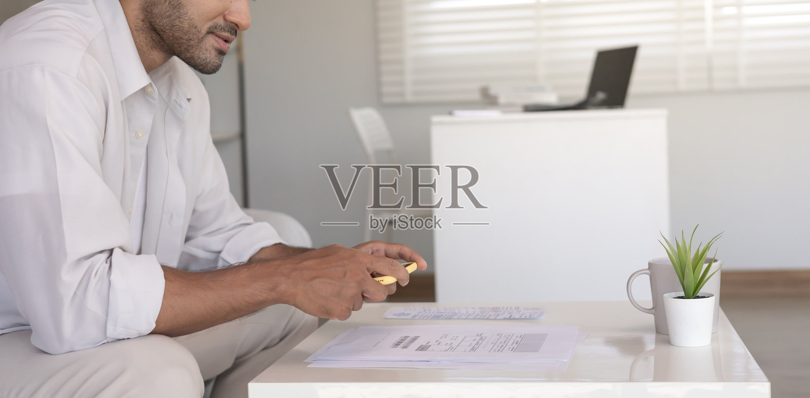 男子使用手机扫描条形码或二维码支付信用卡账单，收到在线发票后进行支付，电费支付，数字支付无需现金，科技。照片摄影图片