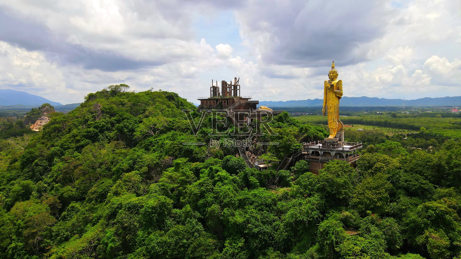 一座位于石灰岩山脉中间的寺庙，周围环绕着美丽的自然风光，这里是Khao Tham Rakhang Thong冥想中心的所在地，中心的亮点是供奉的Luang Pho Yai Chai Mongkol。照片摄影图片