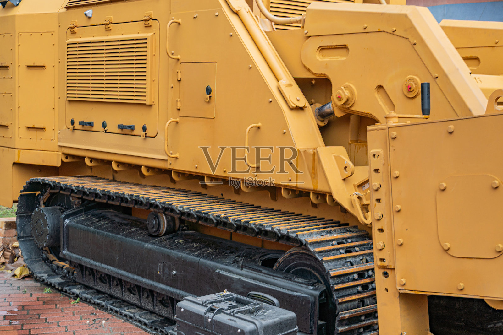 黄色施工车辆，履带，液压缸，挖掘工作机械，泥土或碎片，湿地，自然光，纪录片风格照片摄影图片