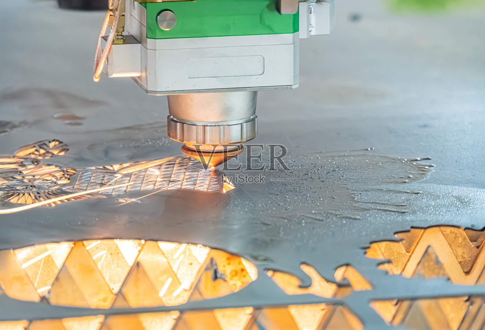 工业激光制造过程中的机床与金属表面的特写视图，材料去除操作，金属板上的独特图案，真实风格，倾斜视角照片摄影图片