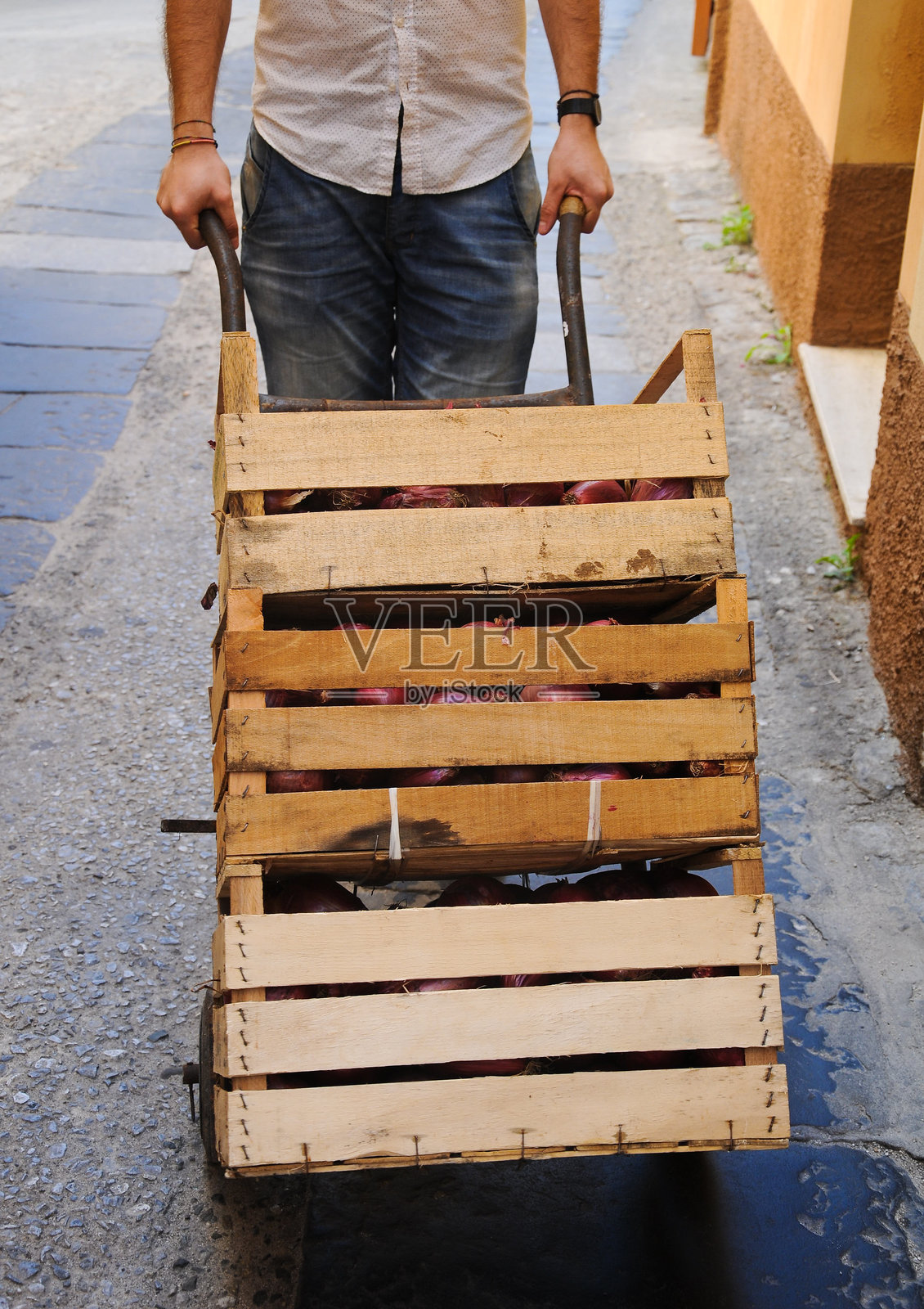 男孩提着装满蔬菜的木箱照片摄影图片