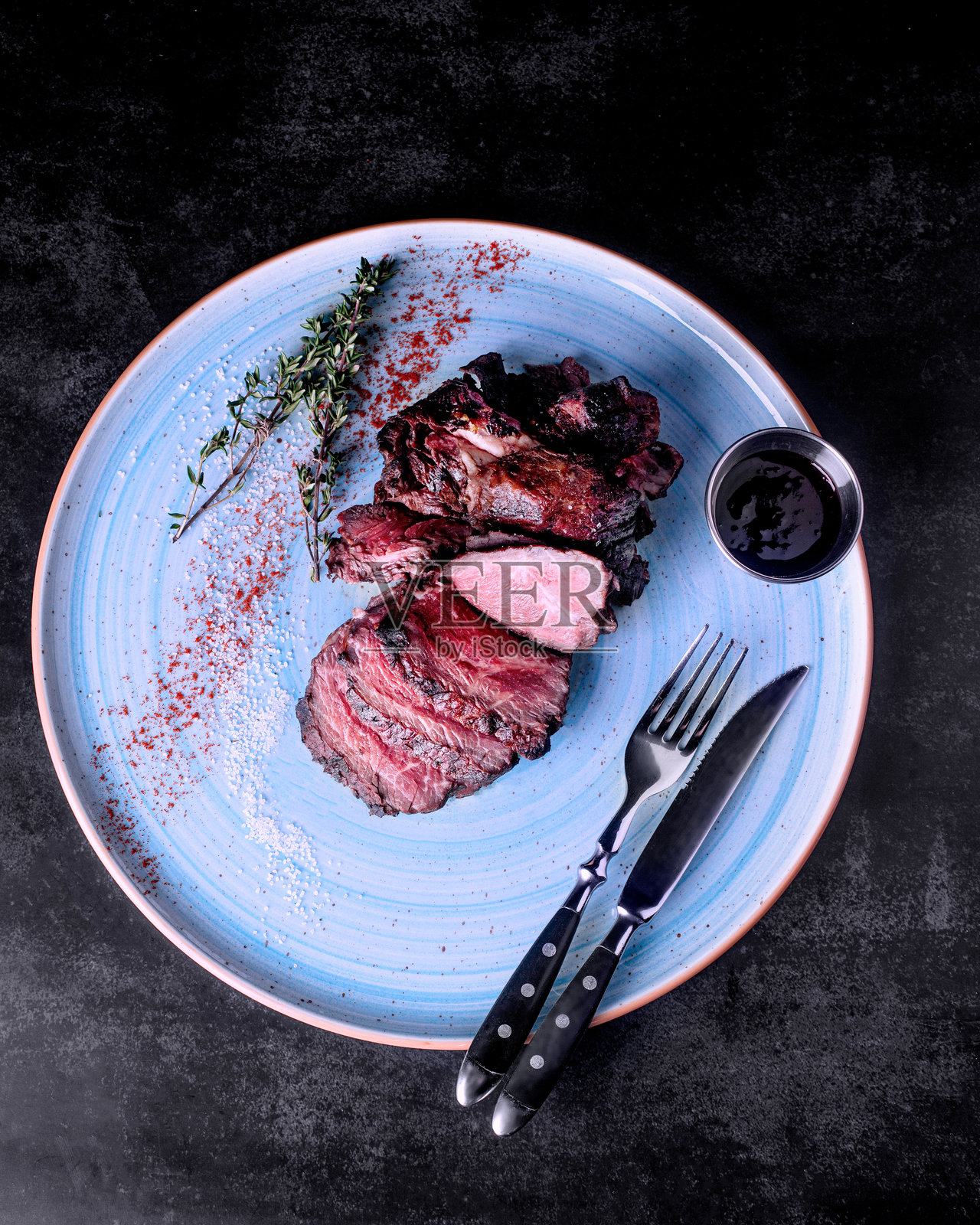 餐厅里的牛排放在蓝色盘子上，俯视图照片摄影图片