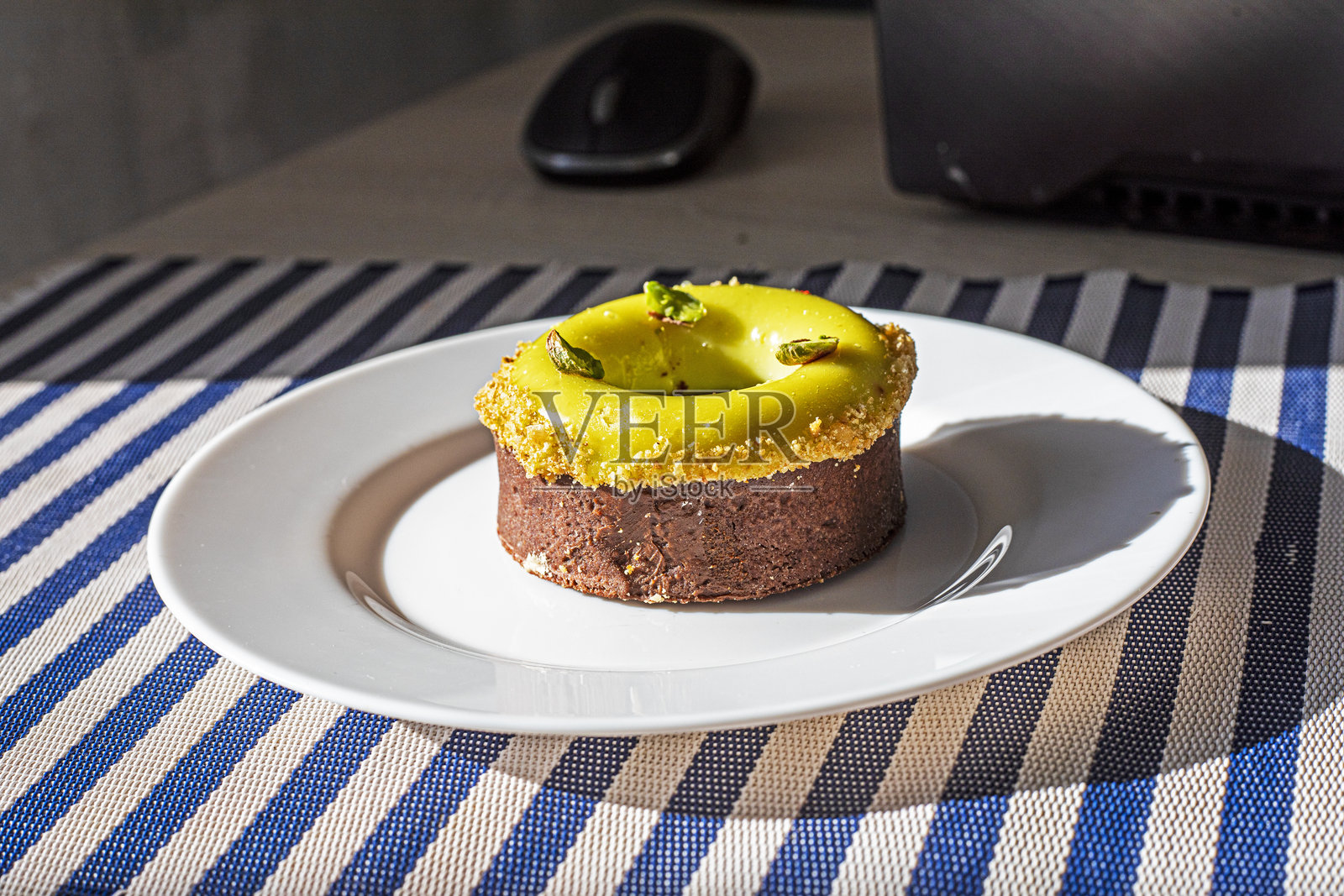 迪拜甜点塔，配有开心果奶油，放在黄色盘子上，旁边有“早安”字样和一台笔记本电脑。照片摄影图片