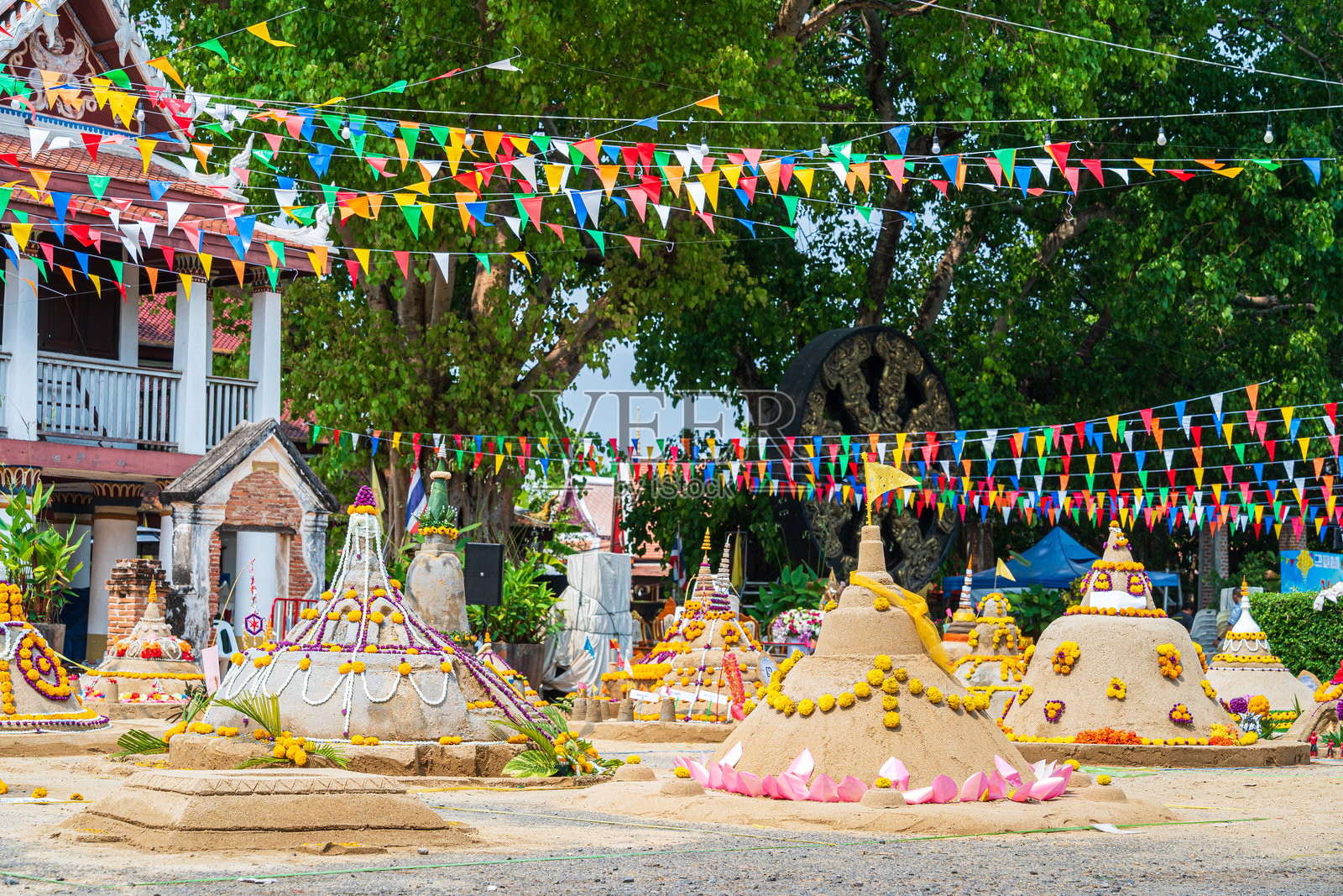 泰国人在佛统府的拉差布拉那寺为宋干节建造沙塔，以将沙子归还寺庙。照片摄影图片