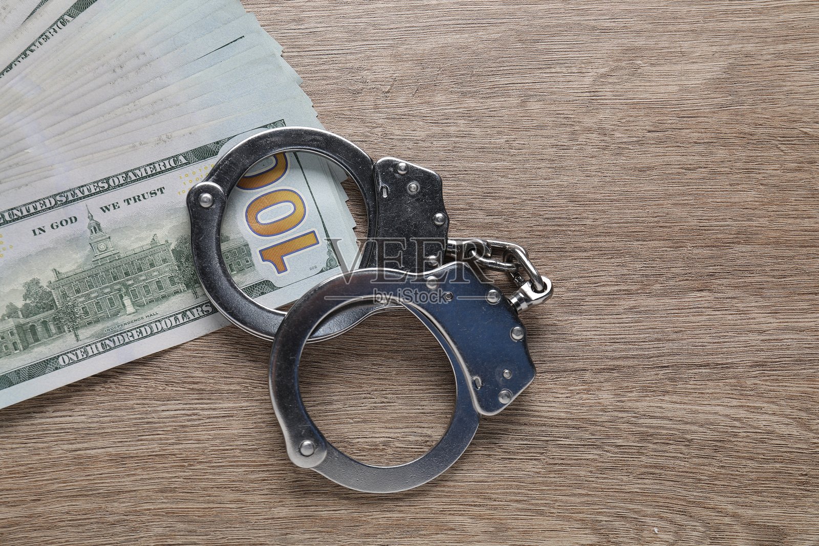 腐败。手铐和美元钞票放在木桌上，俯视图照片摄影图片
