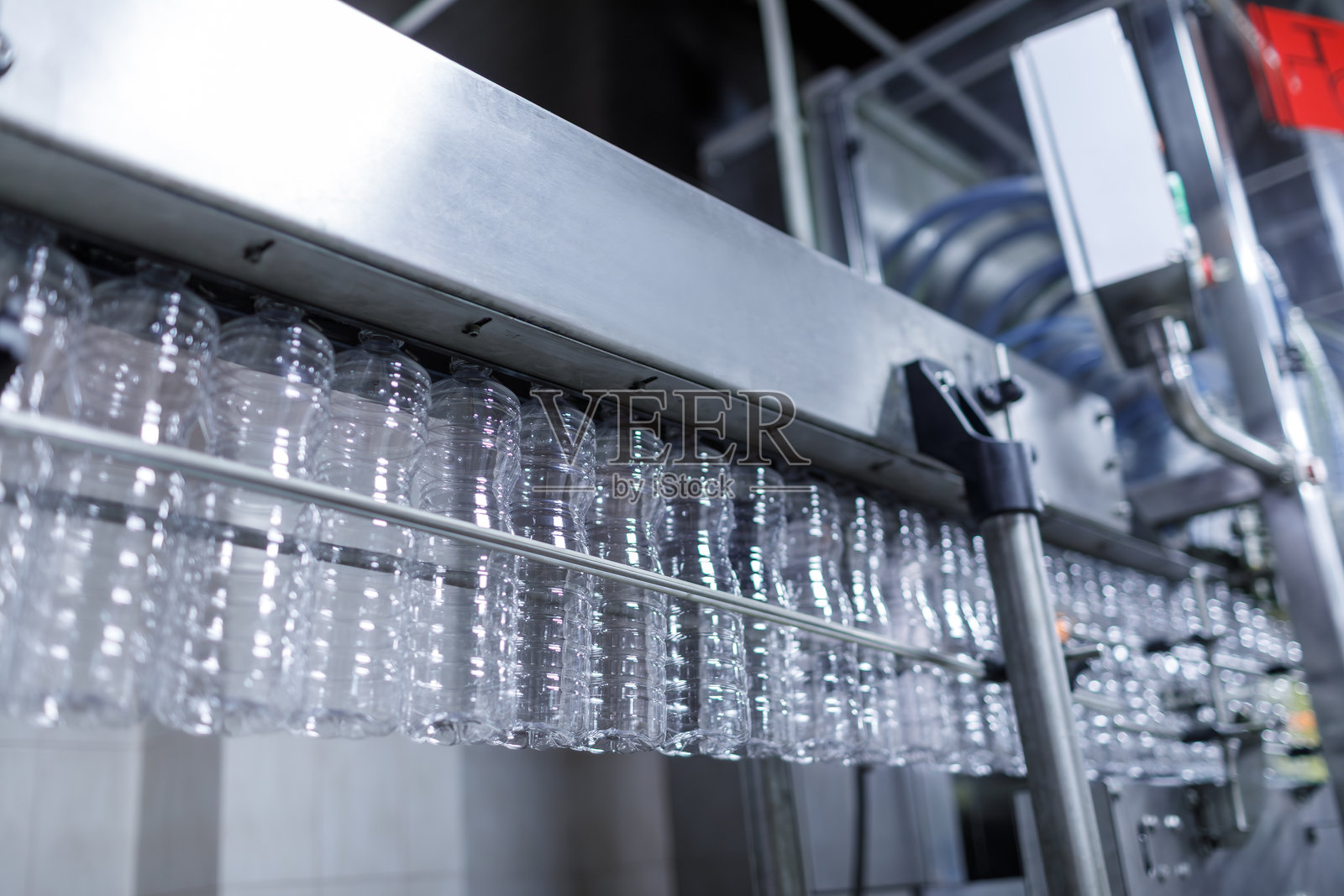 现代工厂中的塑料瓶生产线，空容器在自动化输送系统上移动照片摄影图片