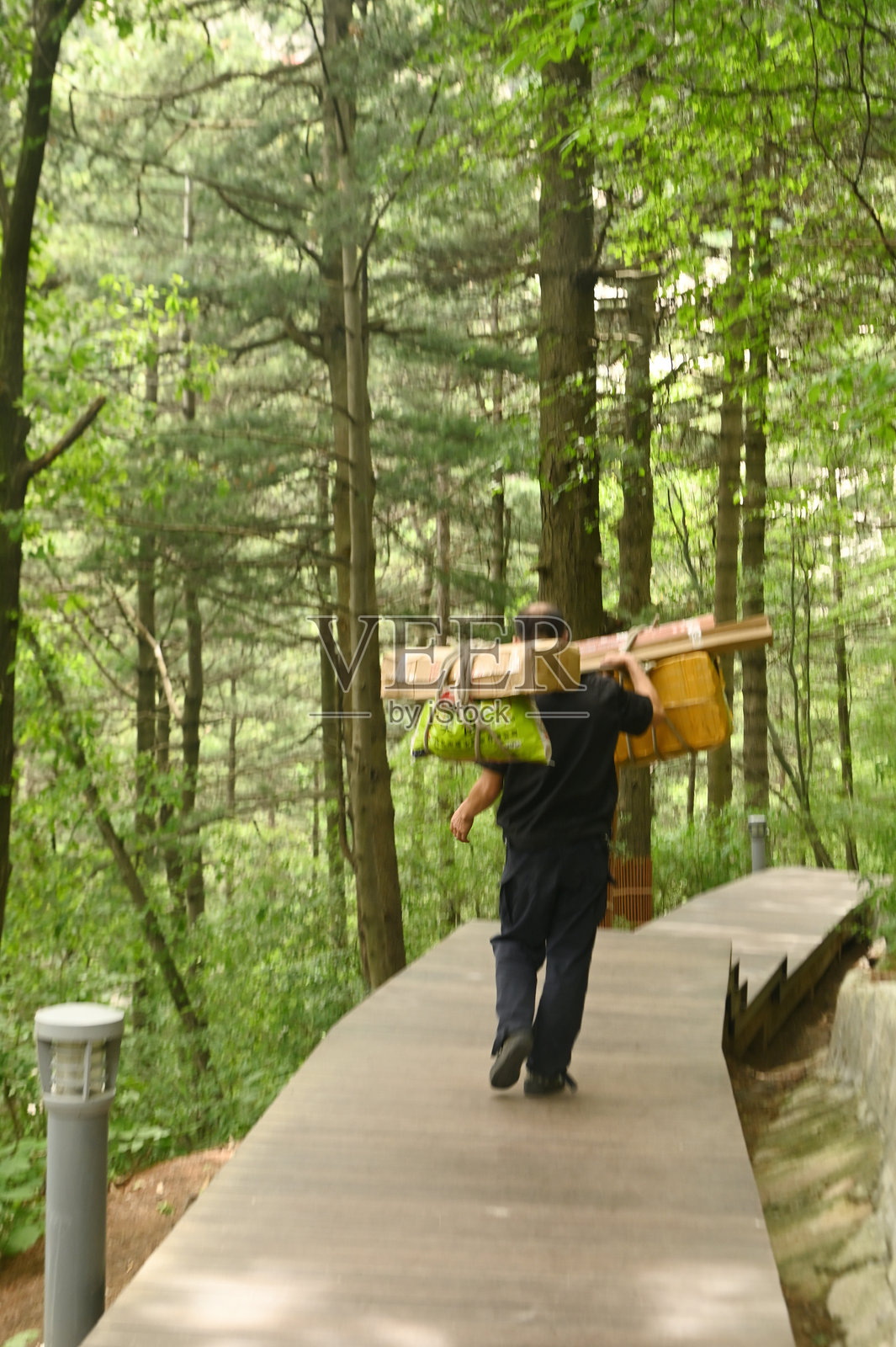 在华山,一名男性工人正在搬运物品,这是中国最著名的旅游景点之一。照片摄影图片
