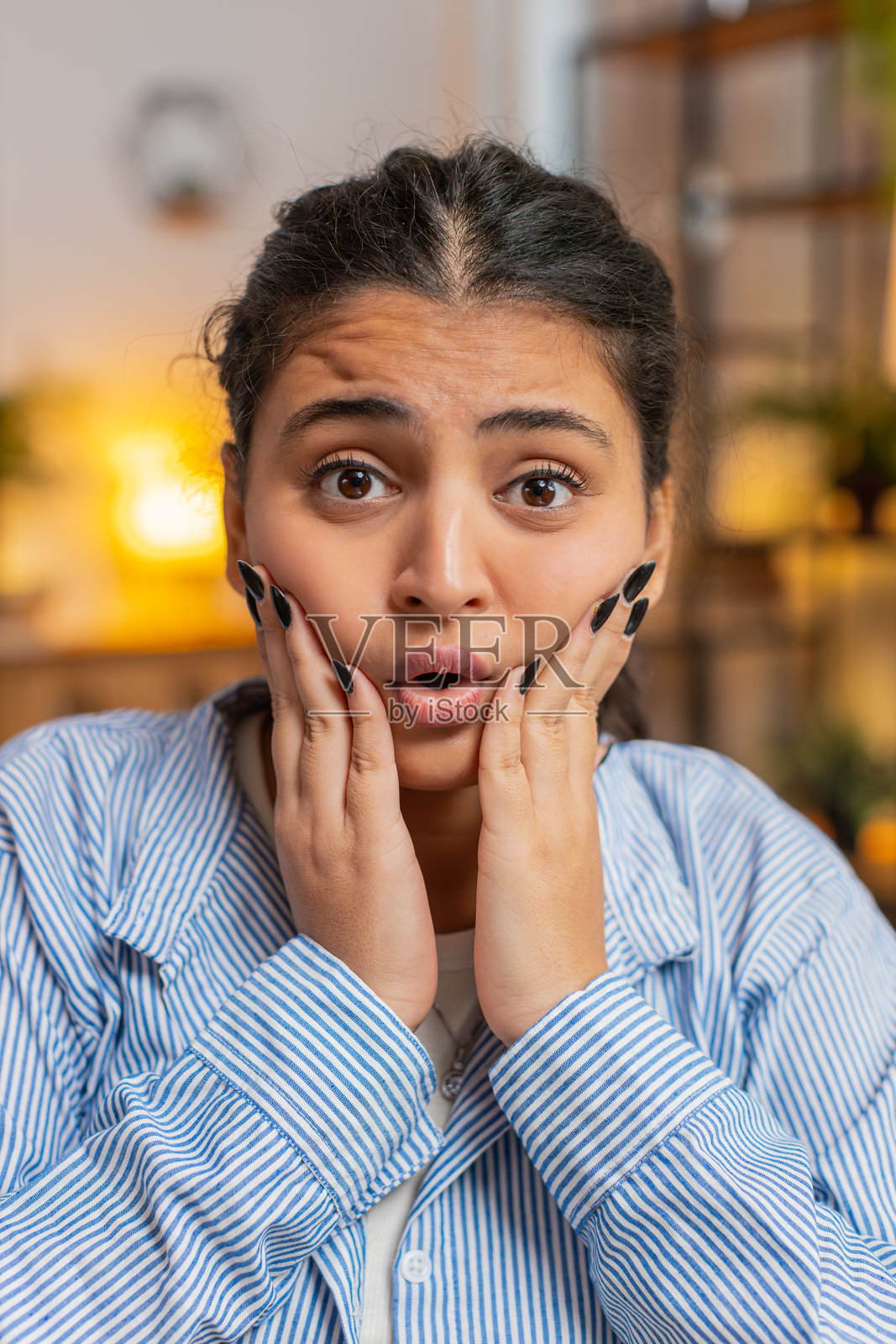 年轻女性感到压力，失望地看着镜头，摇头表示拒绝，坐在家里的桌子旁。照片摄影图片
