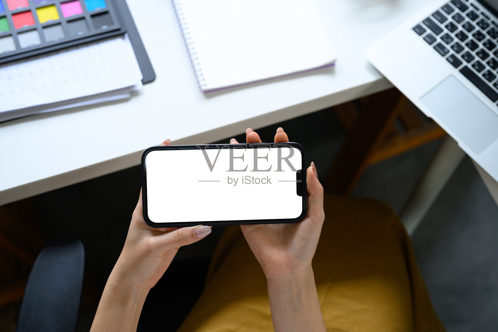 女性在创意工作室中以横屏模式使用智能手机照片摄影图片