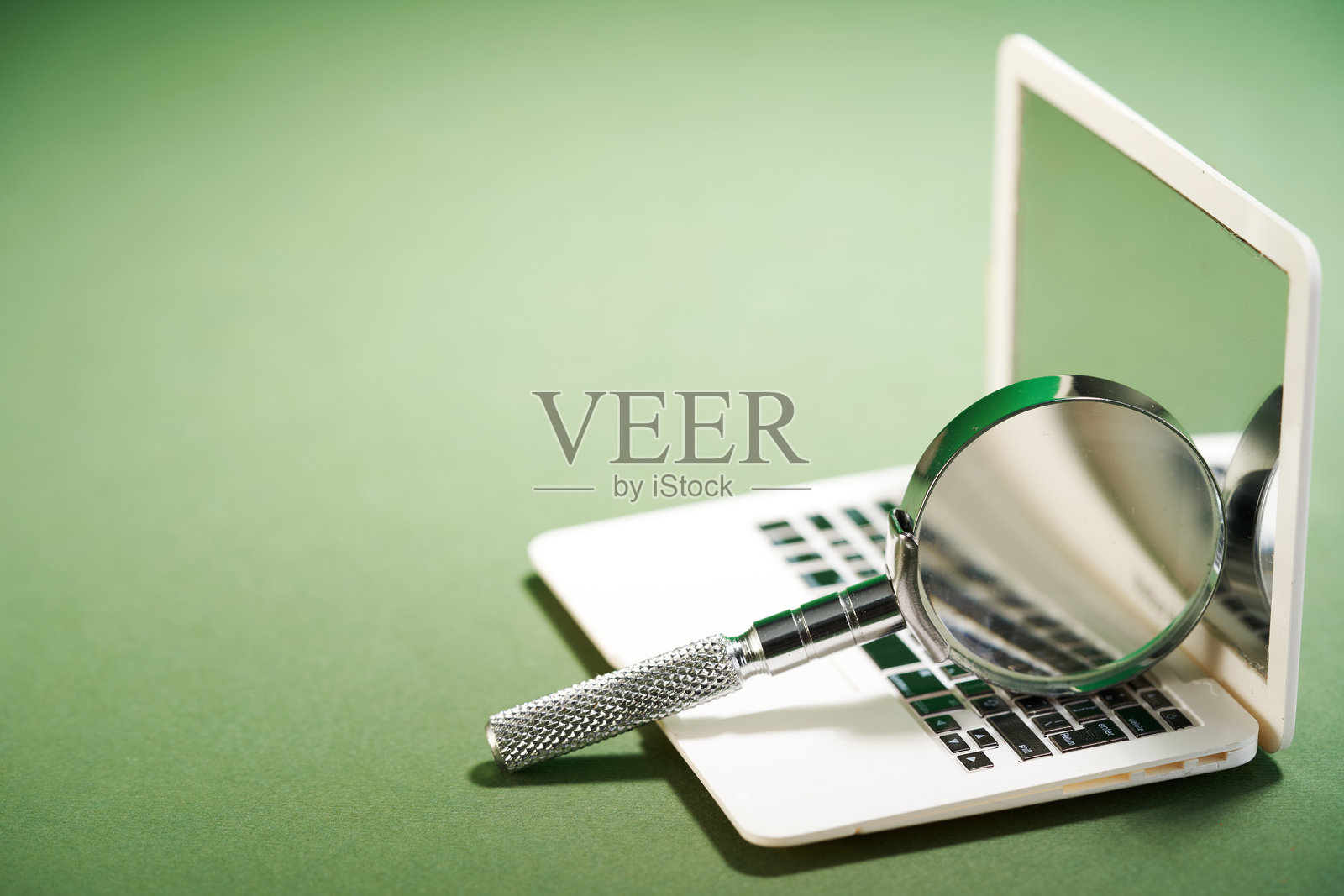 放大镜放在迷你笔记本电脑上照片摄影图片