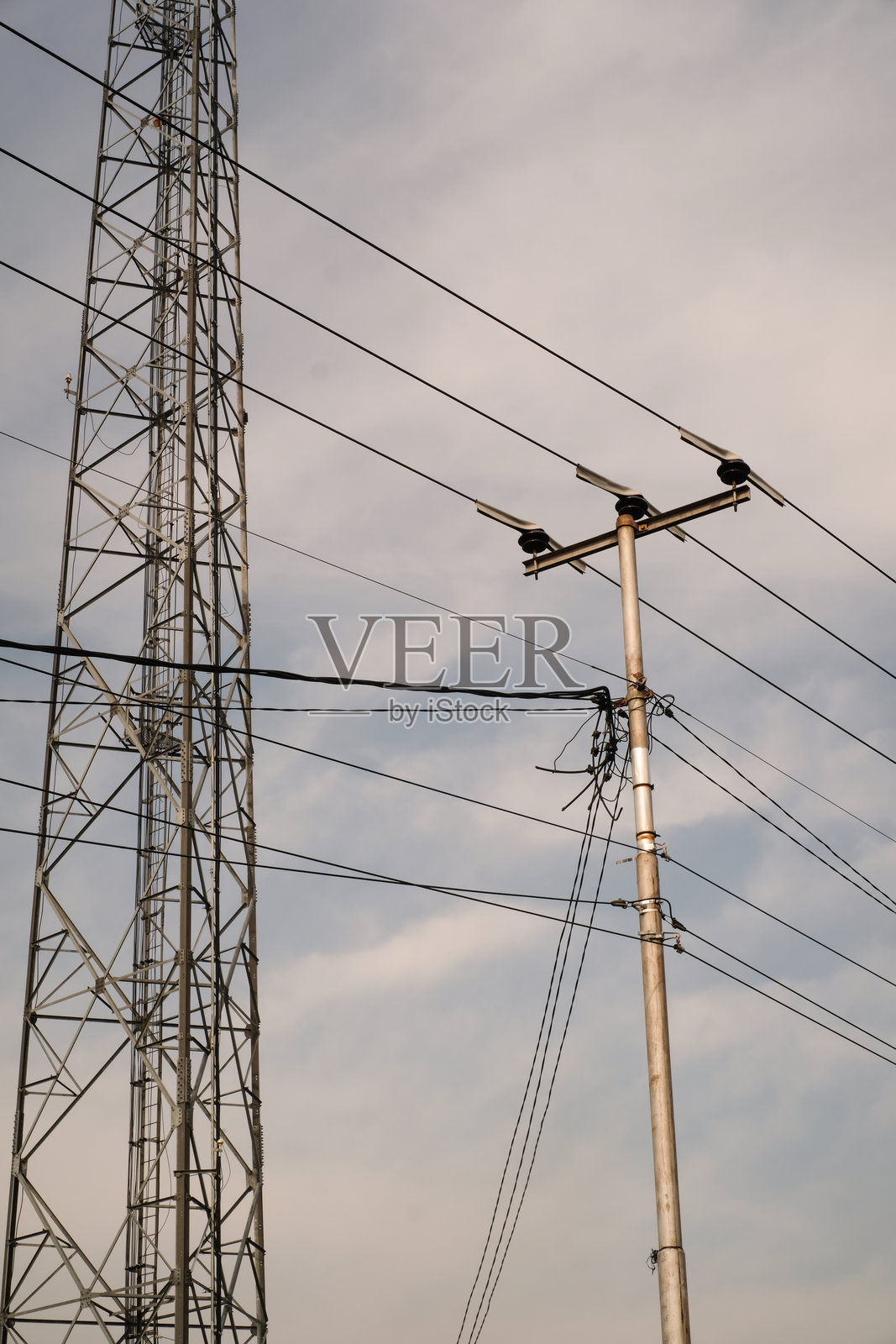 电波信号发射塔与电线杆并排的风景景观照片摄影图片