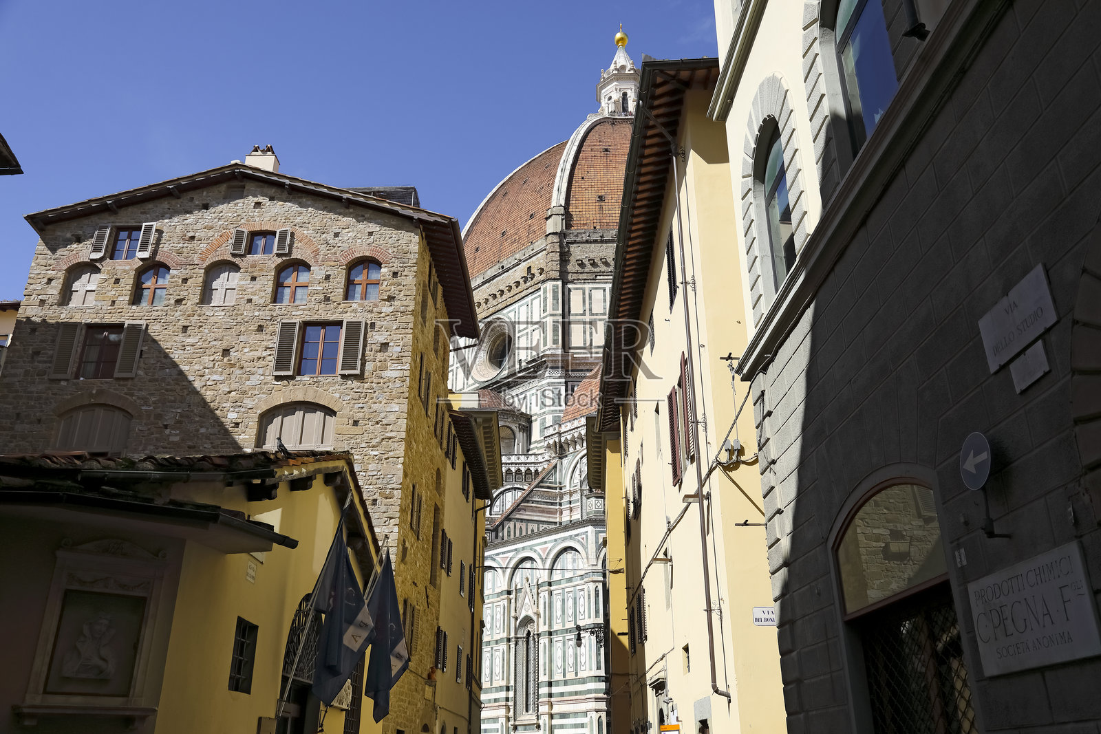 在意大利佛罗伦萨，老城区的房屋之间可以看到大教堂的一小部分。照片摄影图片