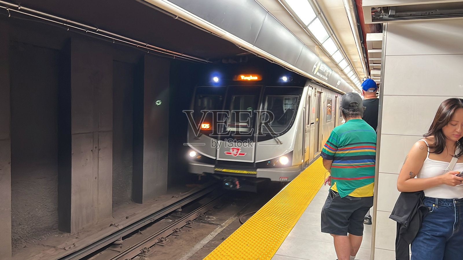 多伦多地铁站,列车到达,乘客在繁忙的通勤时段等候在站台上照片摄影图片