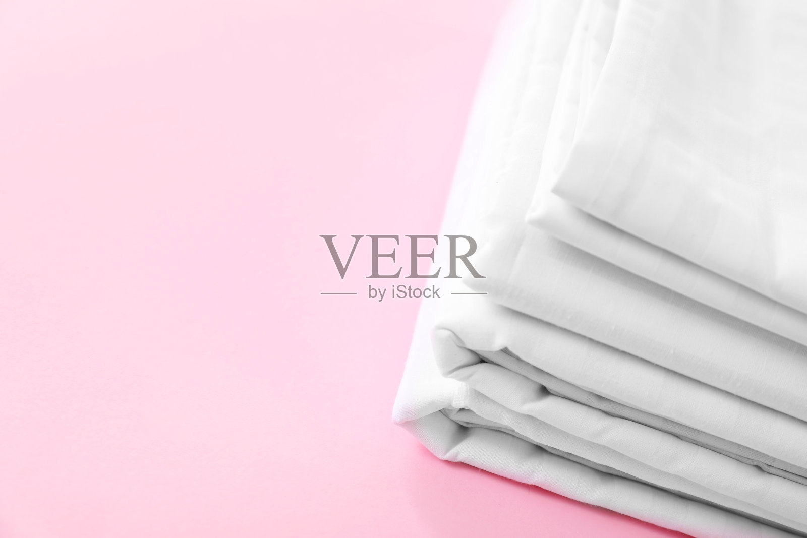 粉色背景上的整齐床单，特写。留有文字空间。照片摄影图片