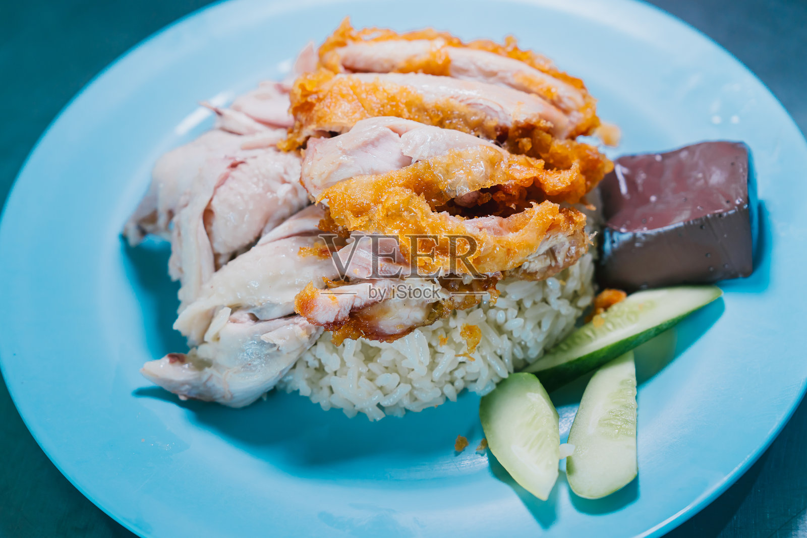 泰国美食：美味的烤鸡饭，配有黄瓜片和蓝色盘子上的果冻甜点照片摄影图片