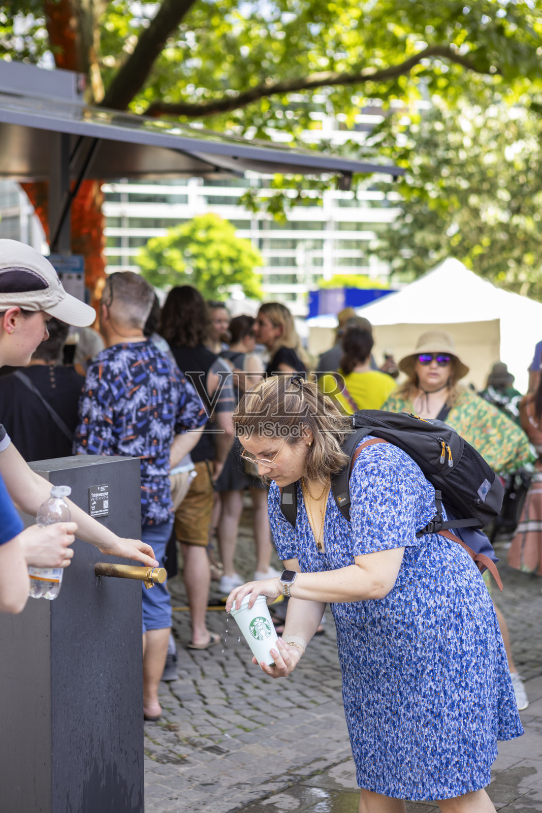 女性在慕尼黑867周年庆典期间于公共喷泉旁清凉解暑 – 2025年6月照片摄影图片