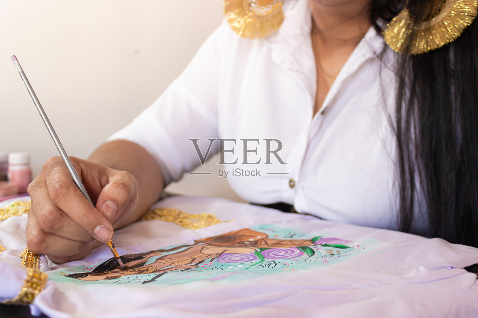 一位女性正在用画笔作画照片摄影图片