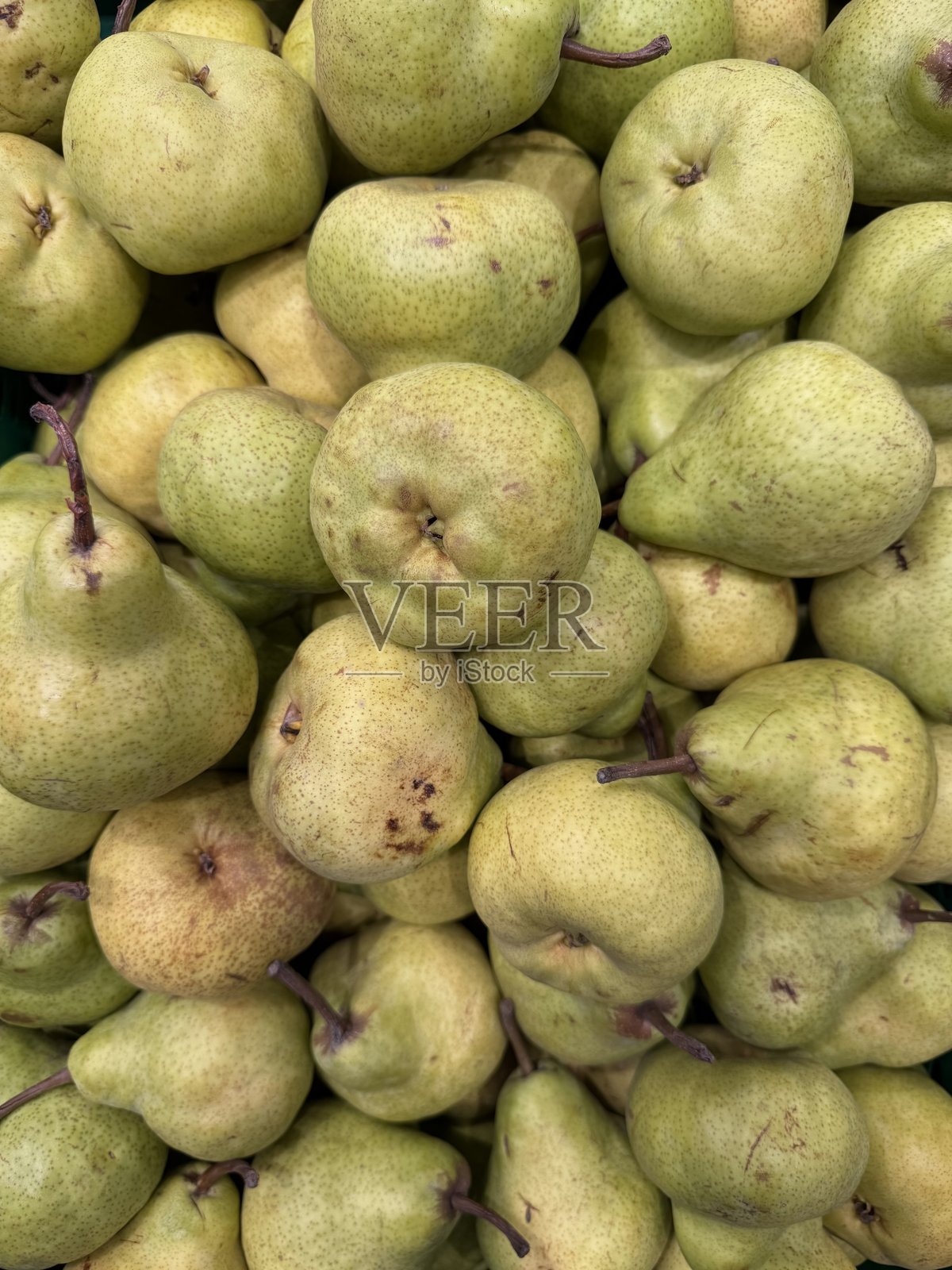 新鲜绿色梨的特写，堆叠在一起。适用于杂货店广告、水果包装、食品博客、营养内容和农业演示。照片摄影图片