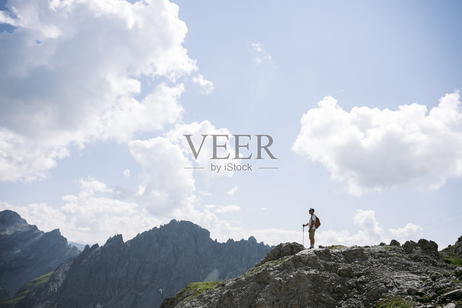 年轻男性登山者到达山顶，享受美丽的风景照片摄影图片