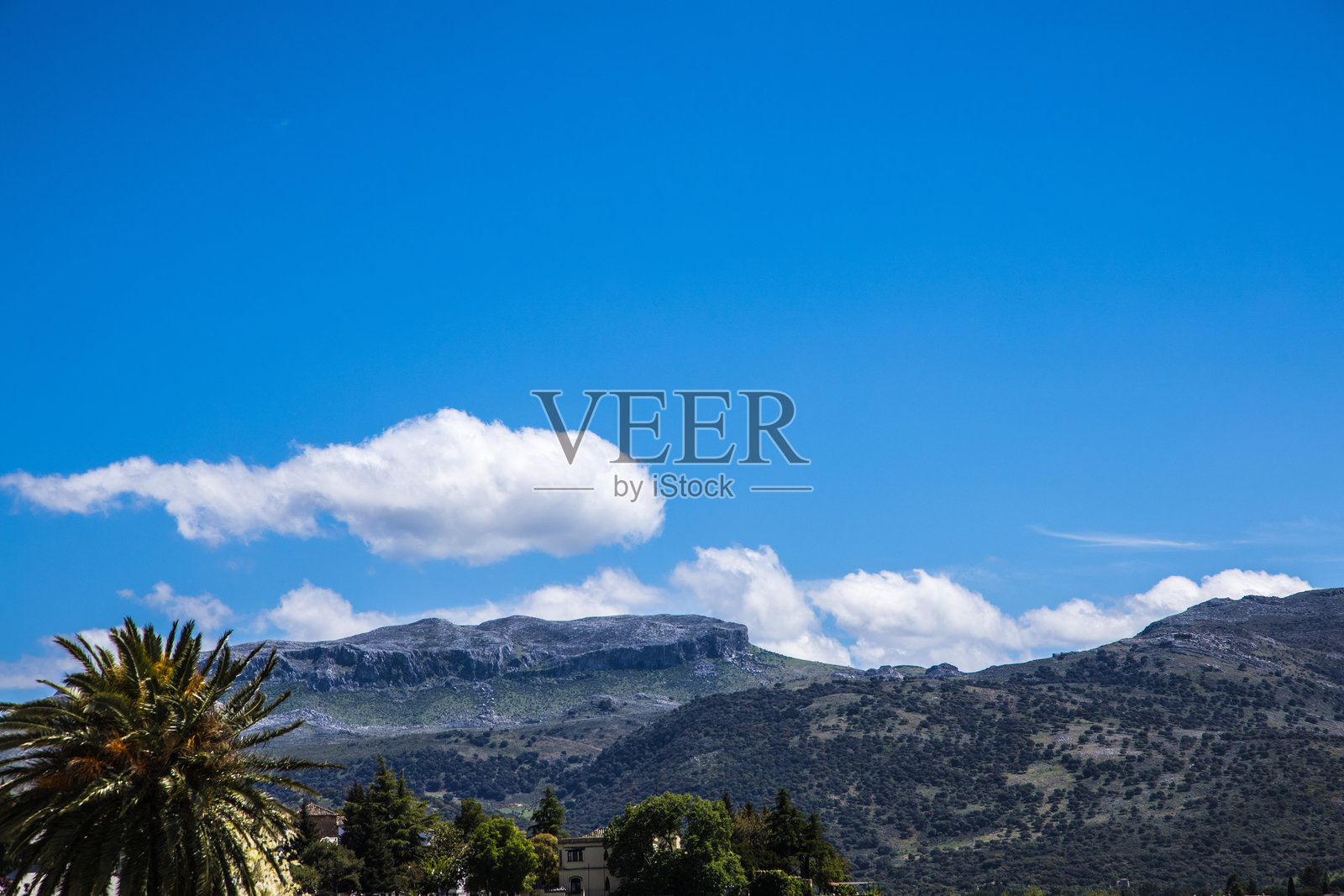 白云覆盖的晴空下的山脉照片摄影图片