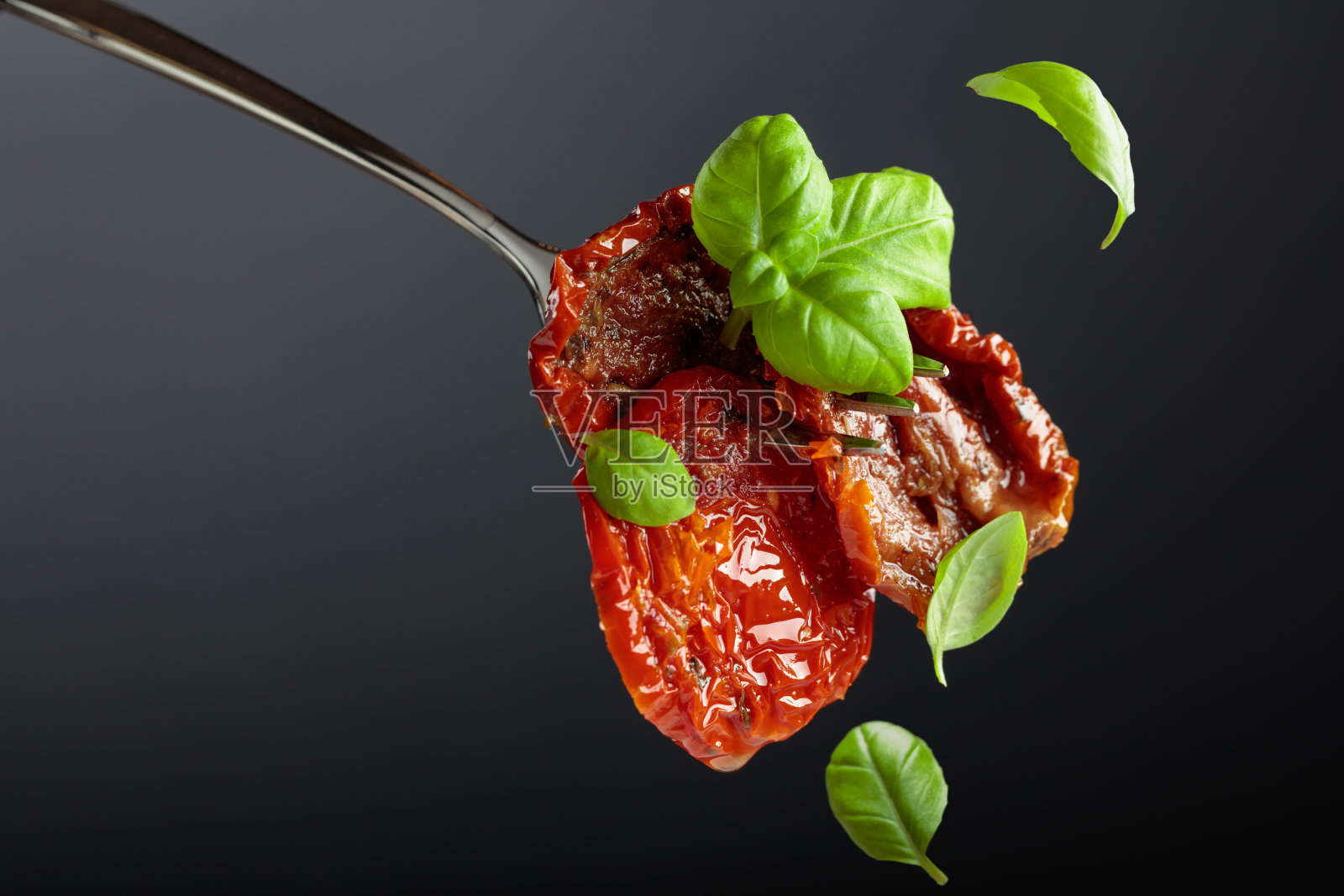 橄榄油浸泡的日晒番茄配绿罗勒。照片摄影图片