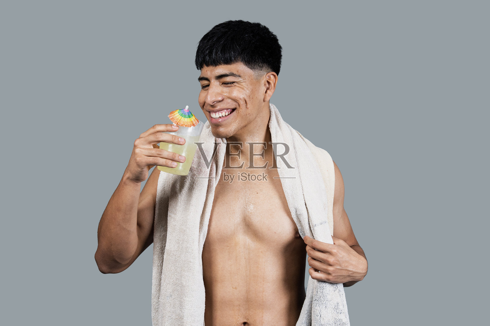 年轻的拉丁裔男子在锻炼后享受清爽饮料照片摄影图片