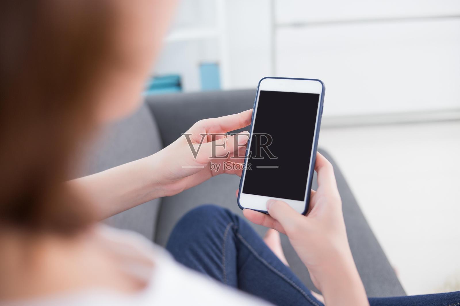 女人在沙发上使用智能手机照片摄影图片
