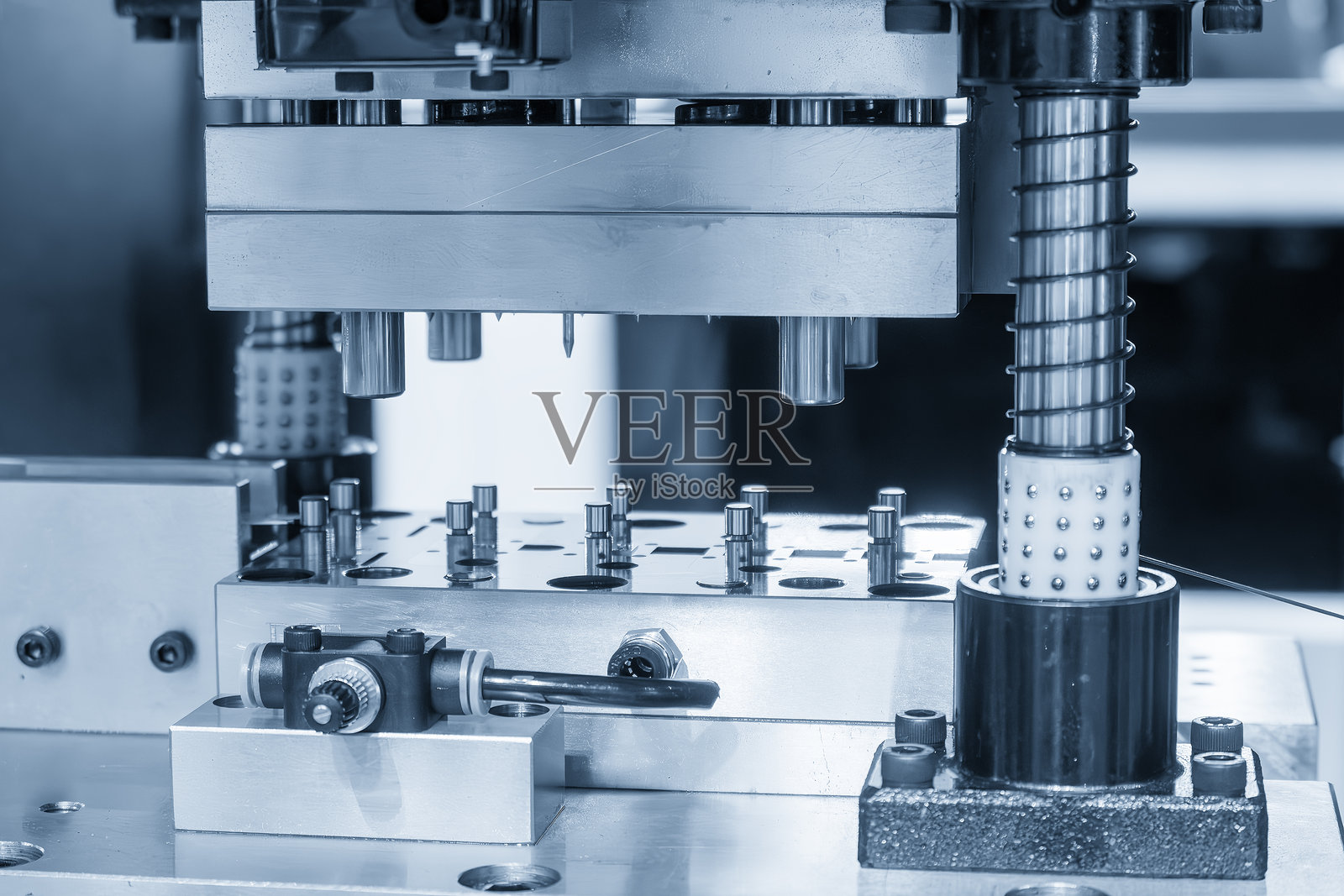 在浅蓝色场景中，电气部件通过渐进模具进行大规模生产。照片摄影图片