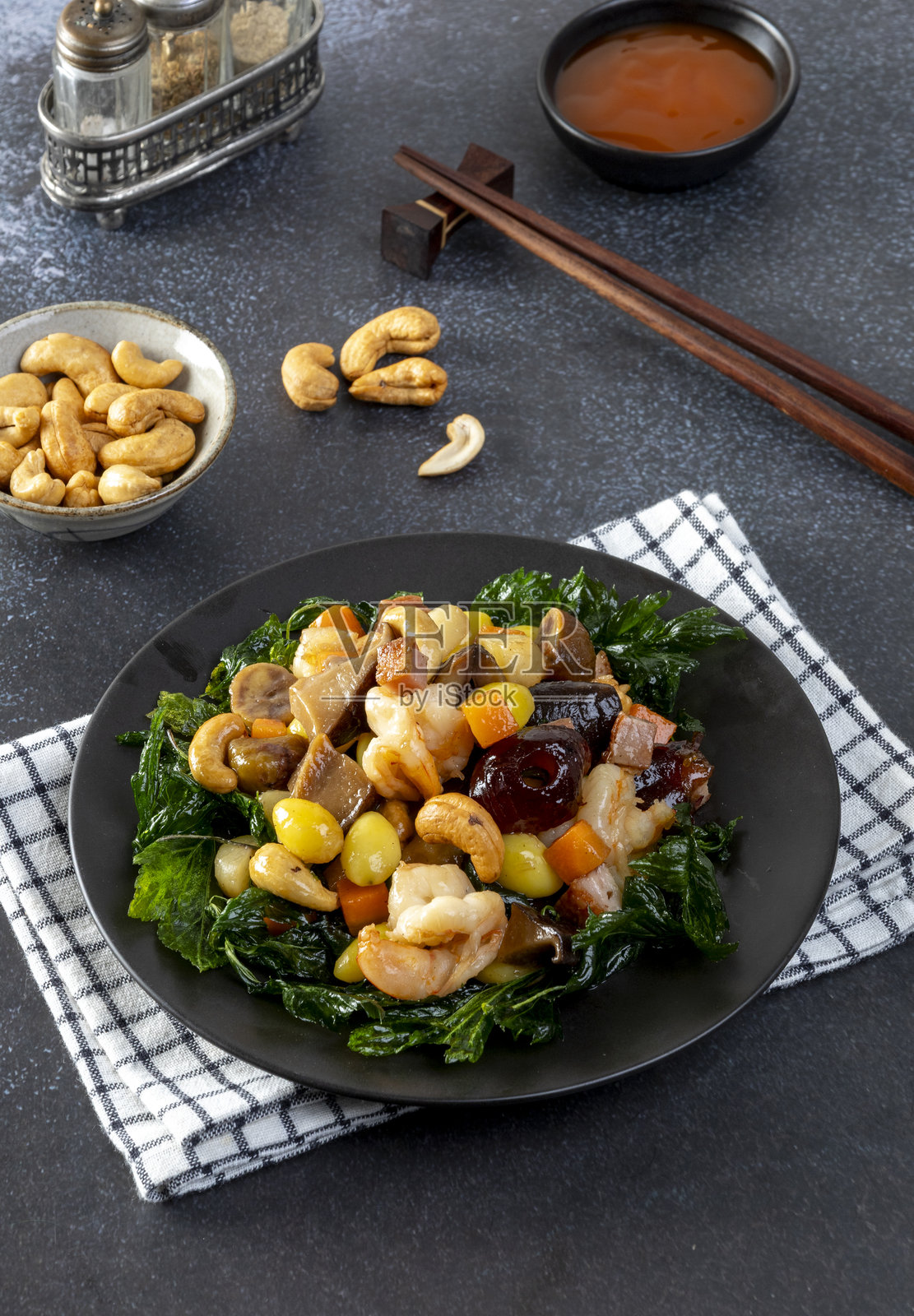 炒杂果坚果盛在黑色盘子上照片摄影图片