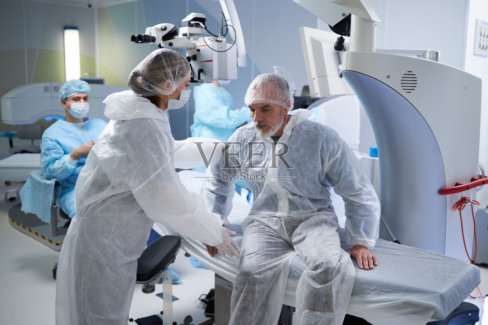 中年男性在手术室接受女性外科医生的帮助照片摄影图片