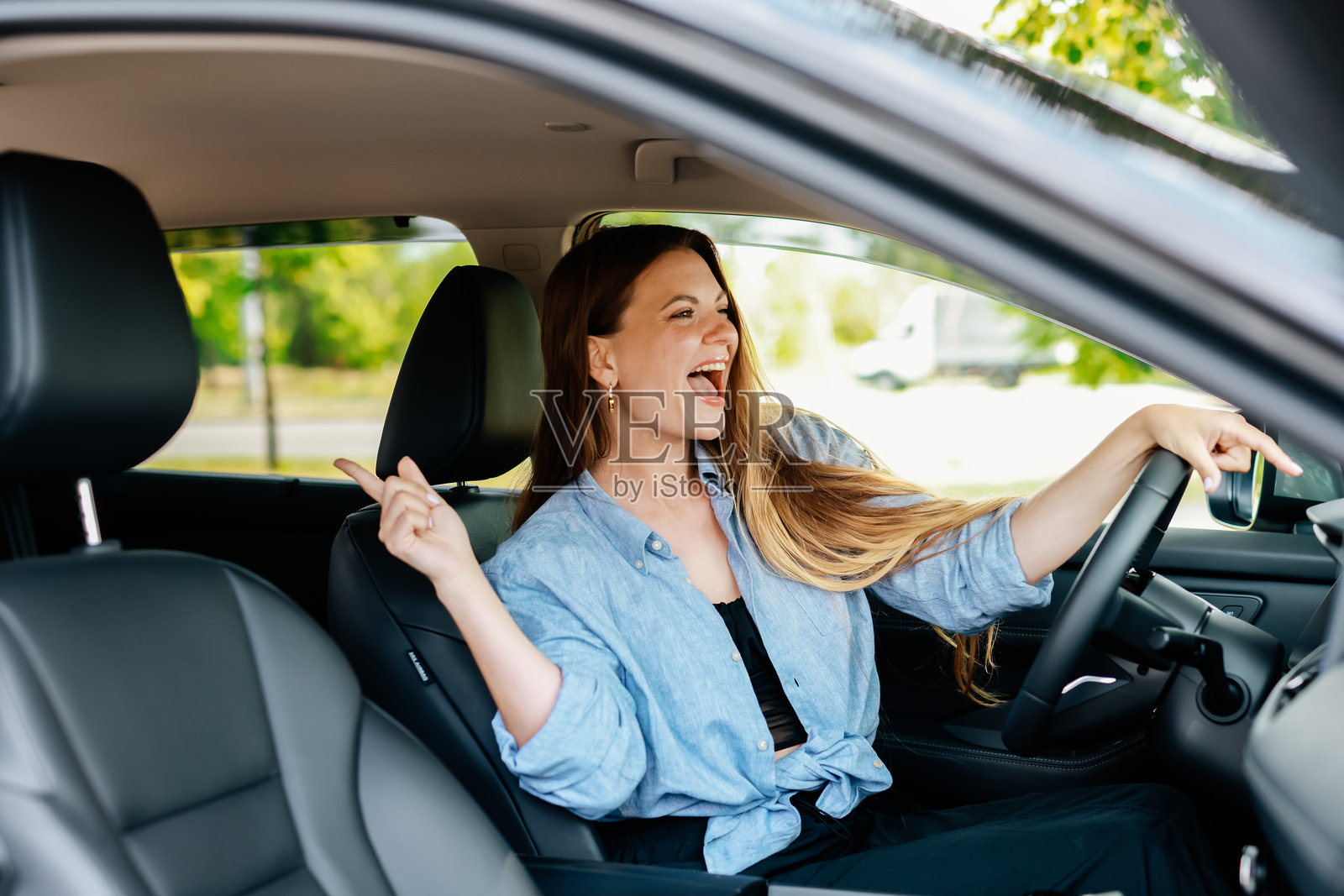 快乐的女性游客独自在车里享受音乐照片摄影图片