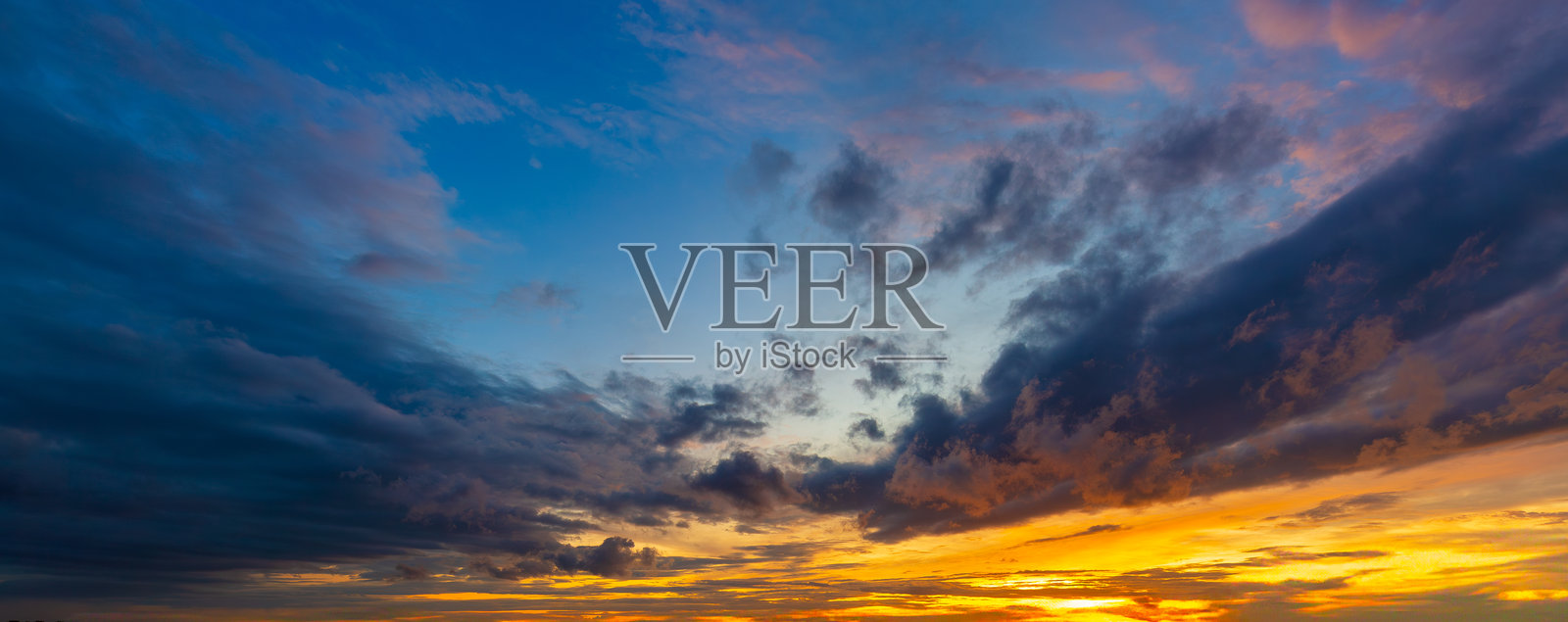 雨云与傍晚的天空，惊艳的日落天际线。傍晚的天空中有明亮多彩的橙色和黄色云彩。照片摄影图片