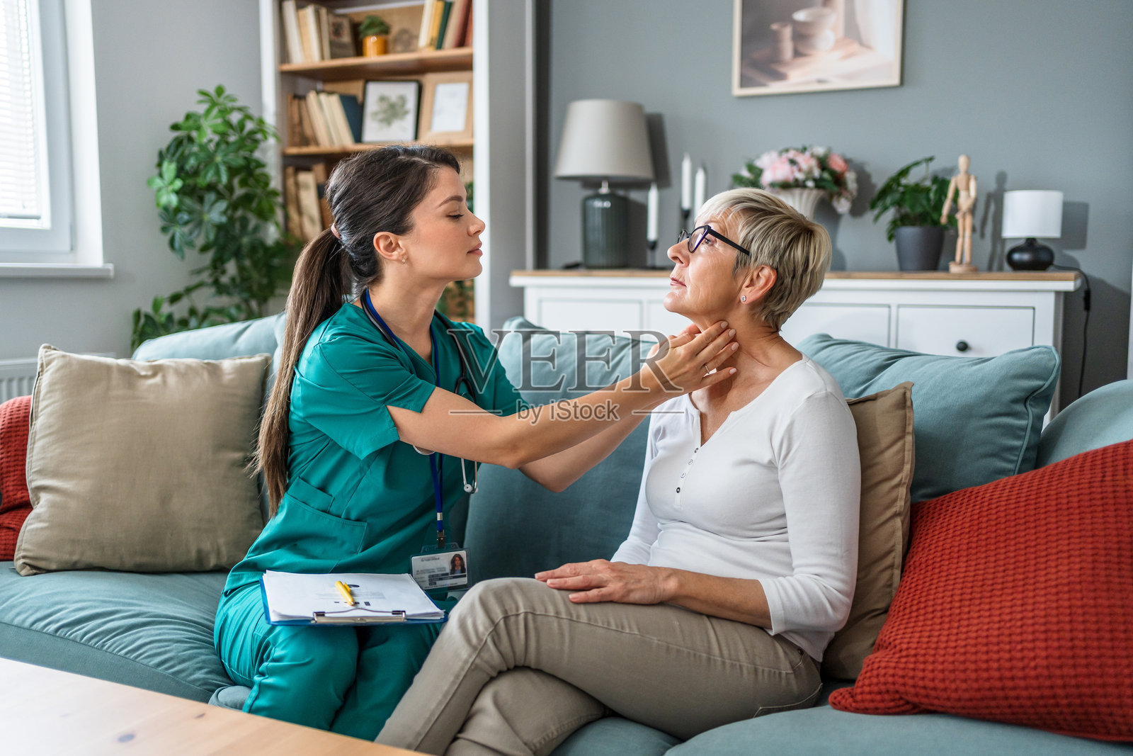 护士在家中检查老年女性的颈部照片摄影图片