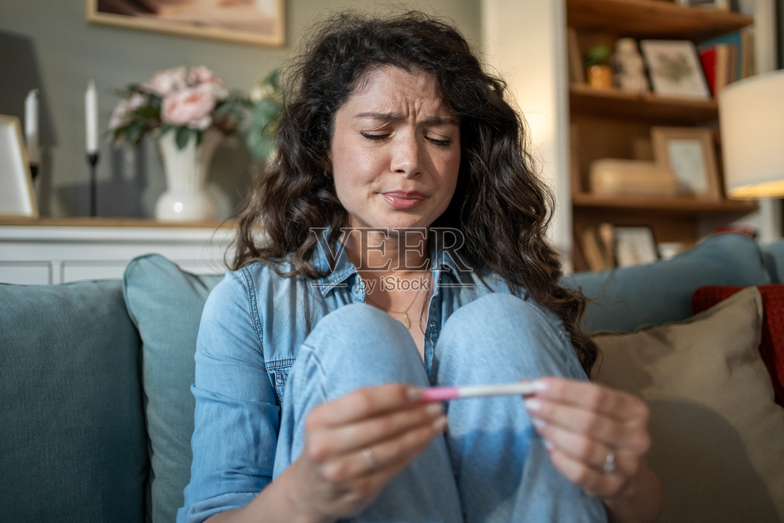 伤心的女人在家中查看阴性的怀孕测试结果照片摄影图片