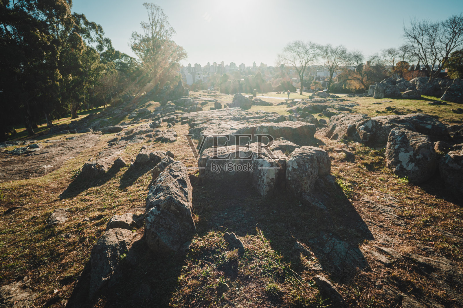年轻的拉丁裔女性在公园里穿着厚衣服，戴上手套并携带一把露营椅。照片摄影图片