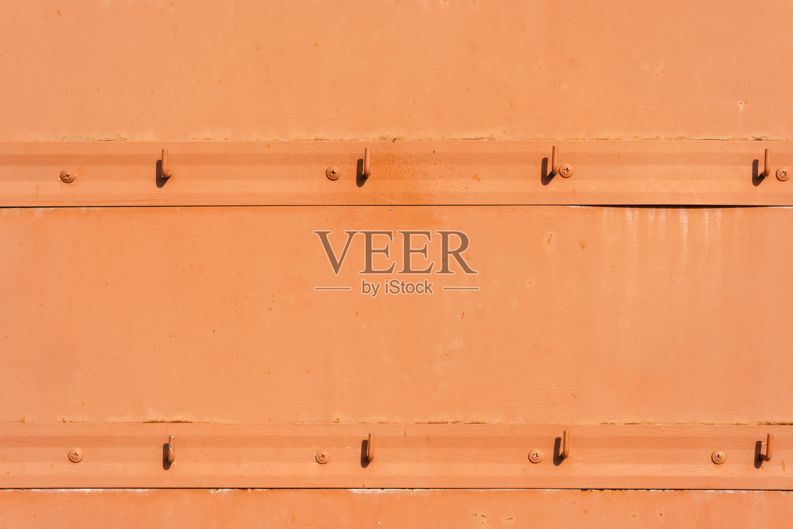 橙色金属墙壁上挂着空钩子照片摄影图片