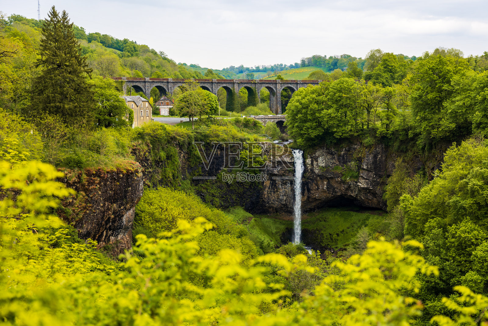 亨利磨坊高架桥横跨奥兹河，位于坎塔尔的萨林瀑布前。照片摄影图片