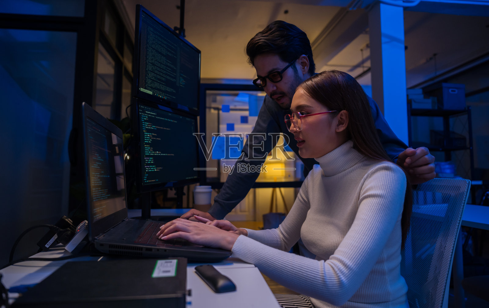 年轻的亚洲商务人士在办公室加班到深夜，开会、头脑风暴，进行关于编码的演示工作照片摄影图片