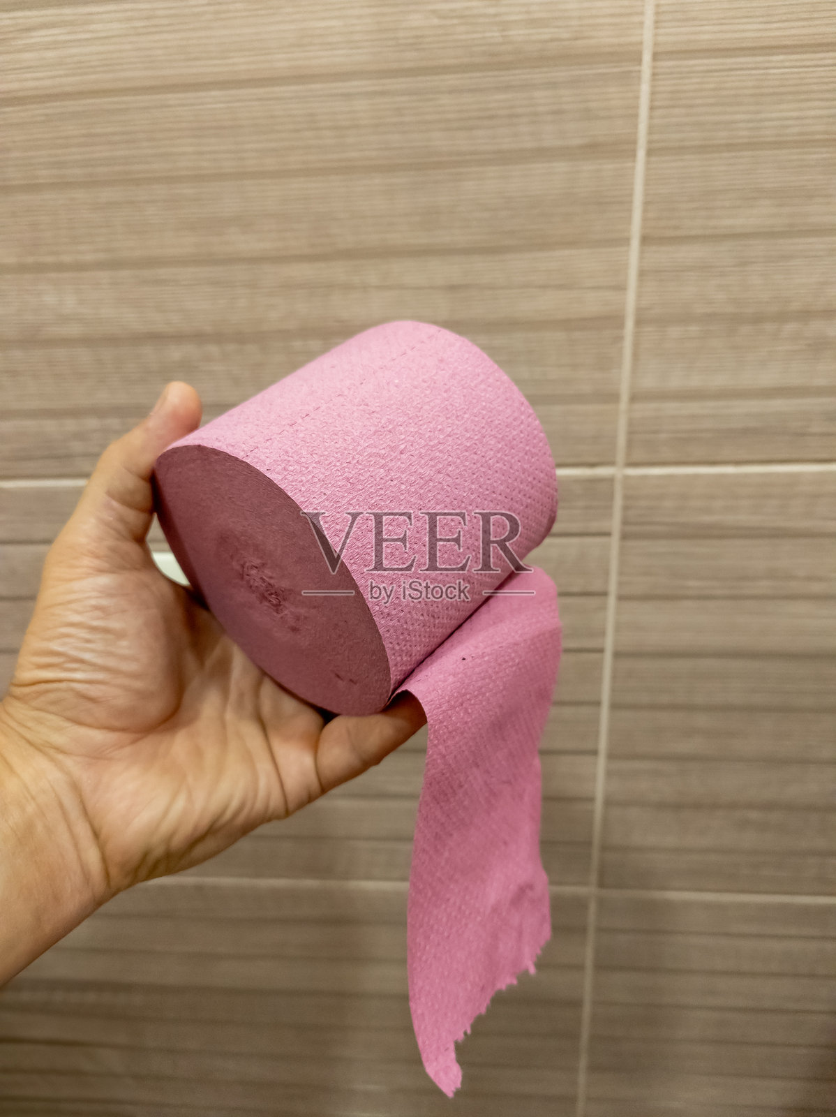 一个人手里拿着一卷粉色卫生纸照片摄影图片