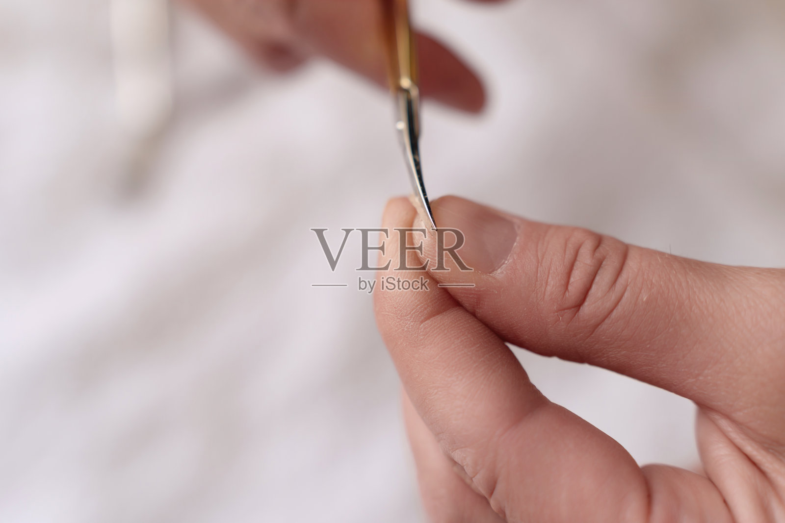 特写镜头展示双手使用剪刀整齐修剪指甲，展现指甲护理方法照片摄影图片