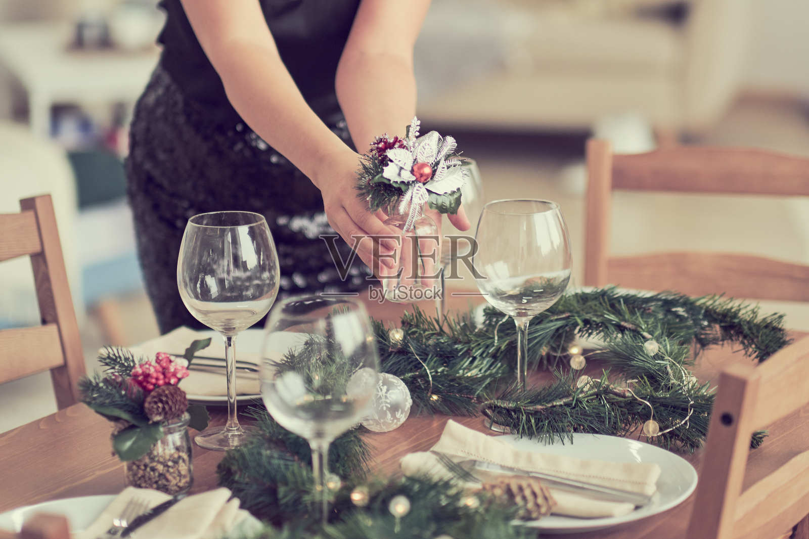 女人在等待客人，正在摆放餐桌。节日的餐桌布置，为圣诞晚餐做准备。照片摄影图片