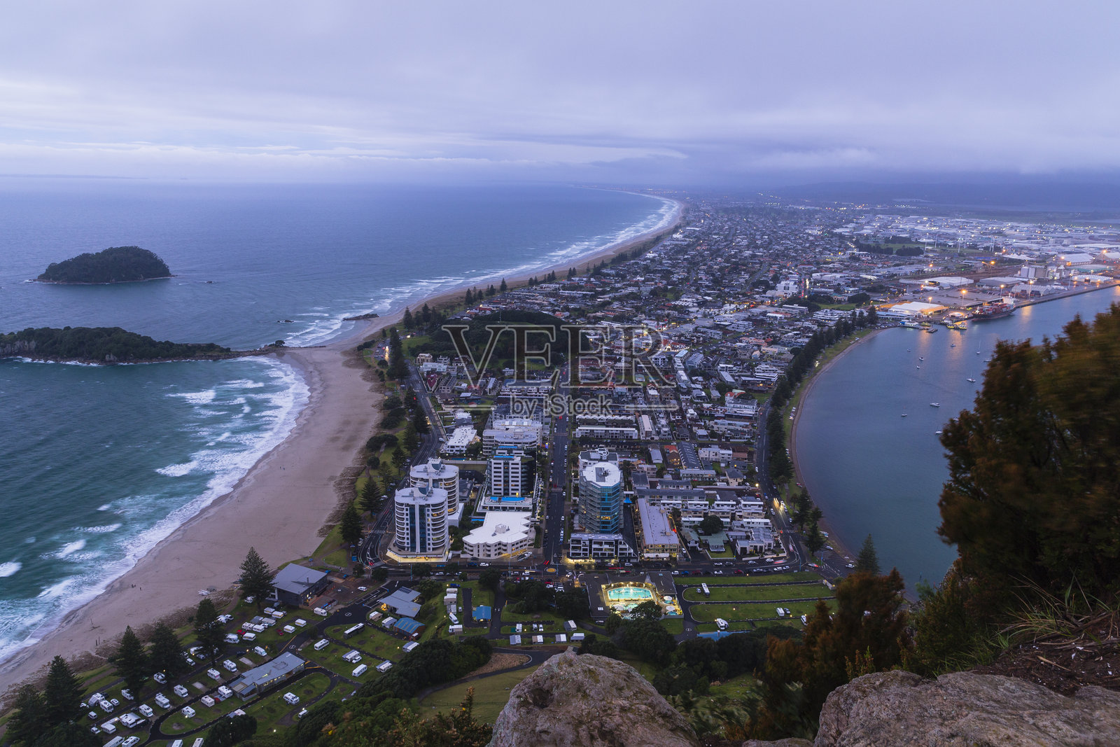 从新西兰丰盛湾陶朗加的毛旺努伊山顶俯瞰城市景观和海滩照片摄影图片