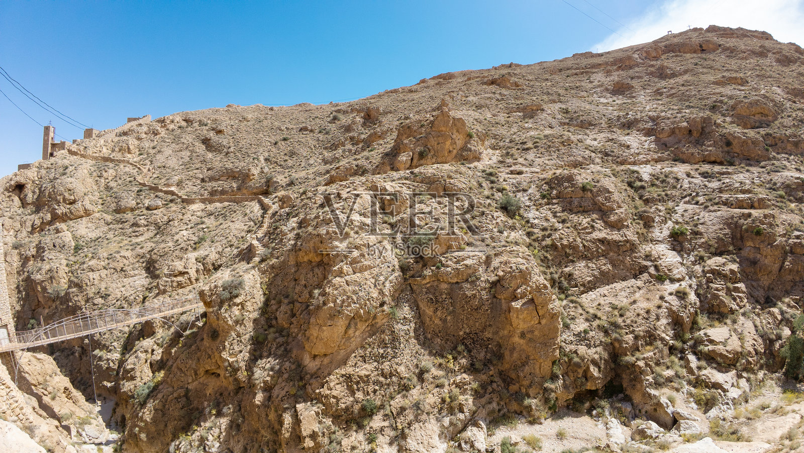 崎岖的沙漠景观与悬索桥照片摄影图片