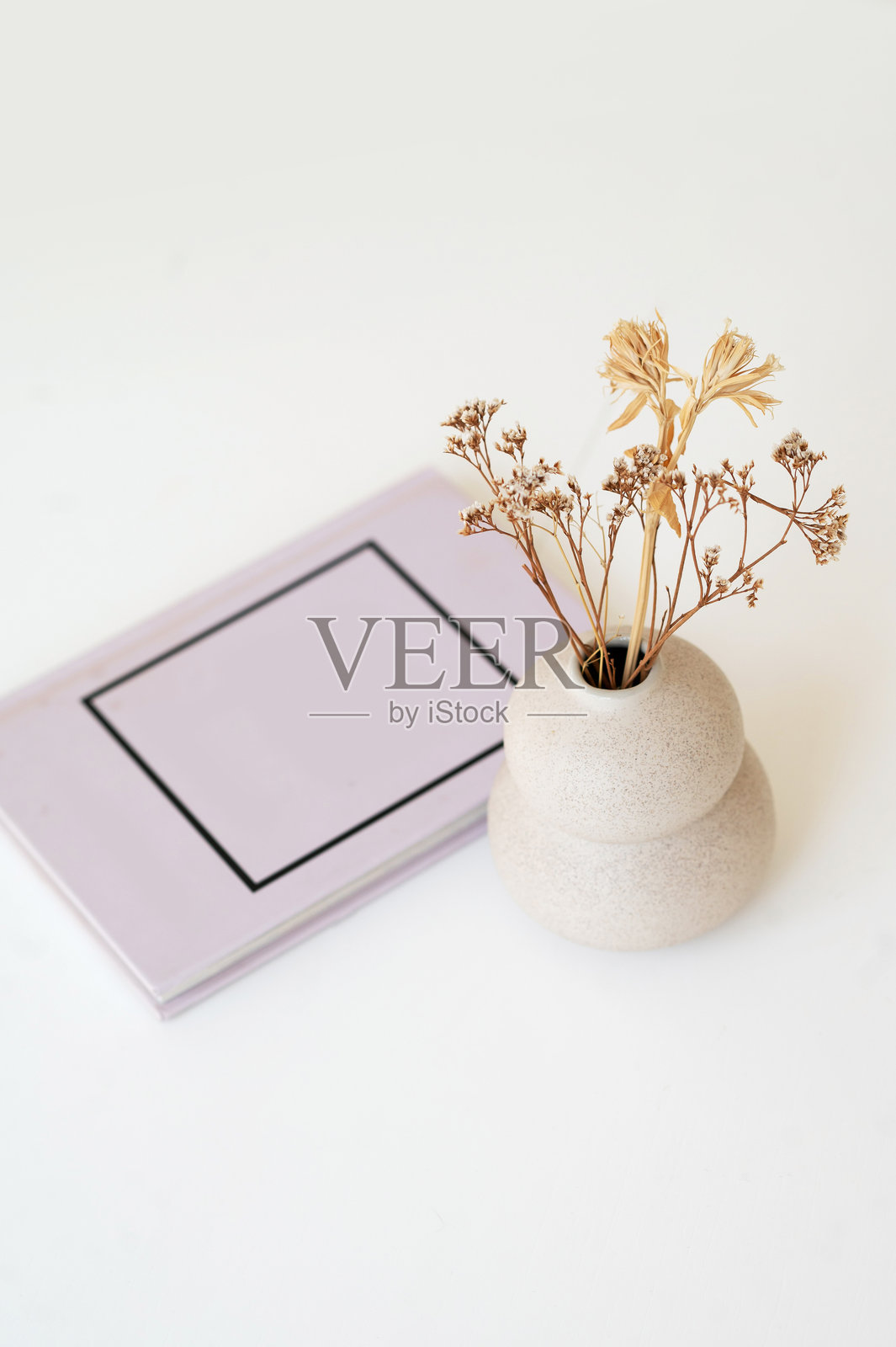 简约花瓶和笔记本放在白色表面上照片摄影图片