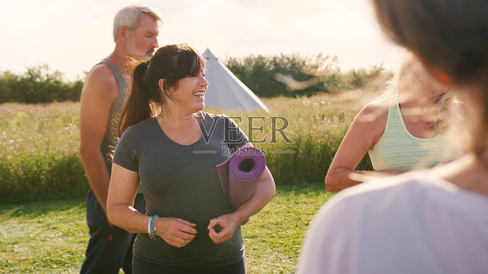 一群成熟的男女在户外瑜伽课上使用瑜伽垫照片摄影图片