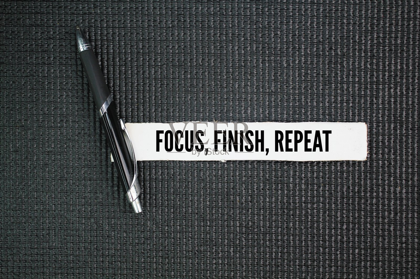一支笔上写着“专注、完成、重复”这三个词，强调集中精力、完成任务和持续练习的重要性。照片摄影图片