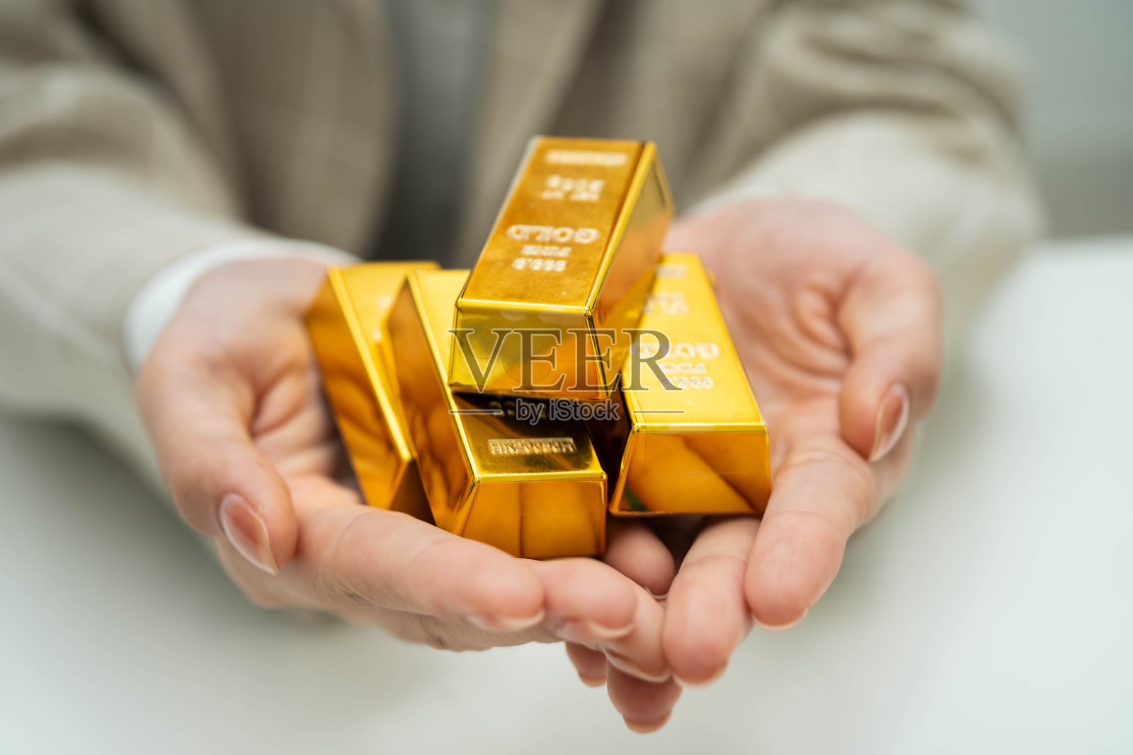 亚洲女性在金融行业中持有金条。照片摄影图片